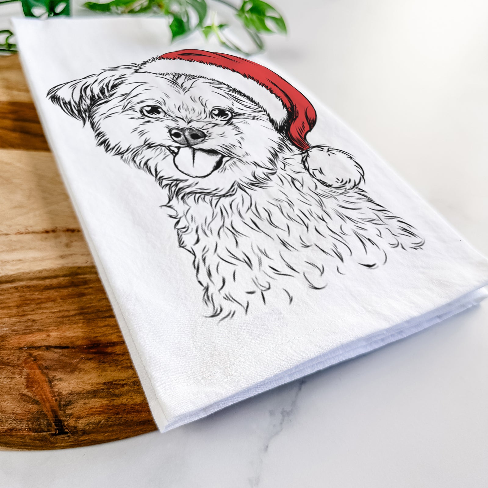 Hand-drawn sketch of Puff the Malshi wearing a Santa hat on a tea towel
