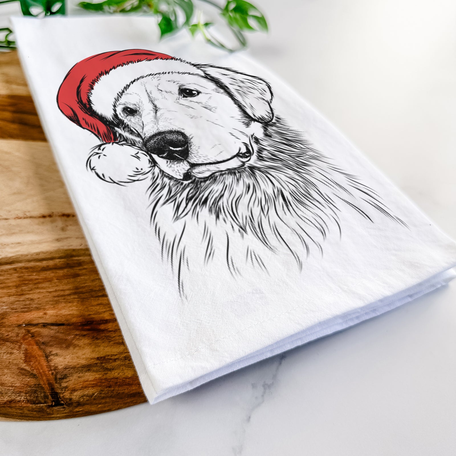 Hand-drawn sketch of Quinn the Golden Retriever wearing a Santa hat on a tea towel