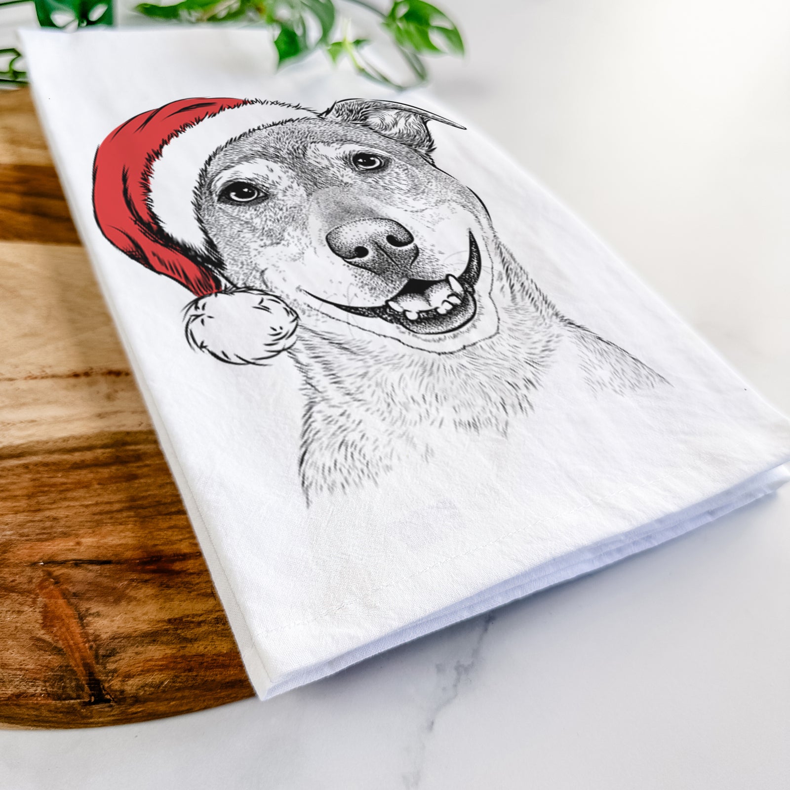 Hand-drawn sketch of Reese the Mountain Cur wearing a Santa hat on a tea towel