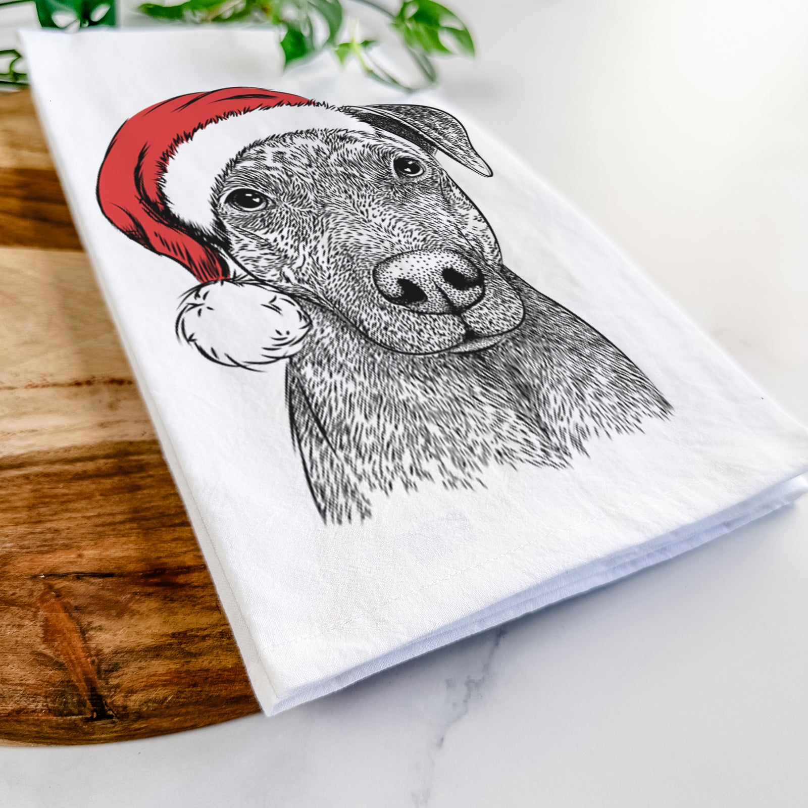 Hand-drawn sketch of Reeses the Pitbull wearing a Santa hat on a tea towel