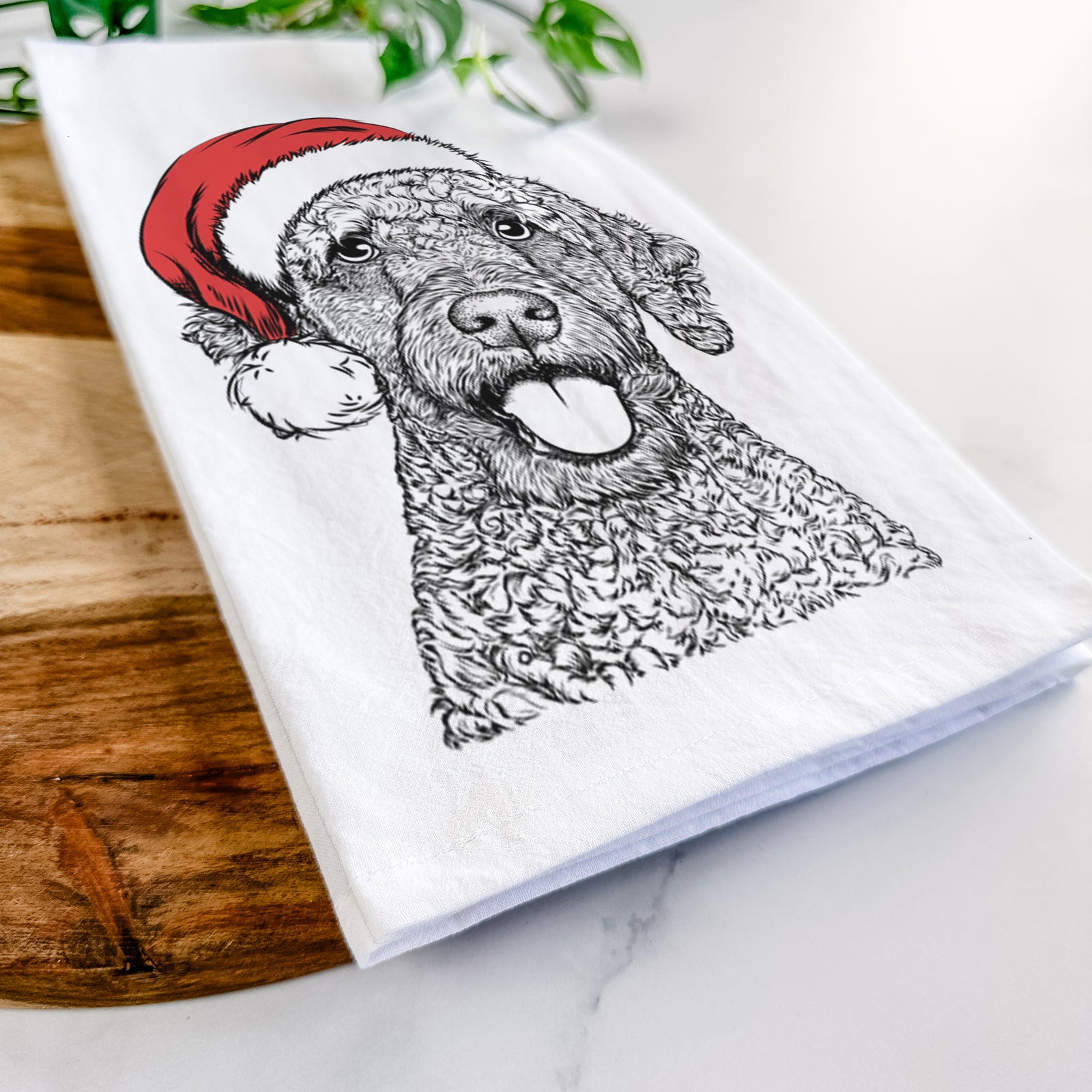 Hand-drawn sketch of Reina the Spanish Water Dog wearing a Santa hat on a tea towel