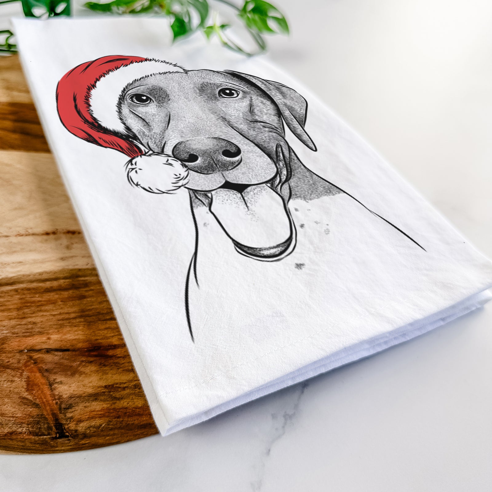 Hand-drawn sketch of Remi the German Shorthaired Pointer wearing a Santa hat on a tea towel