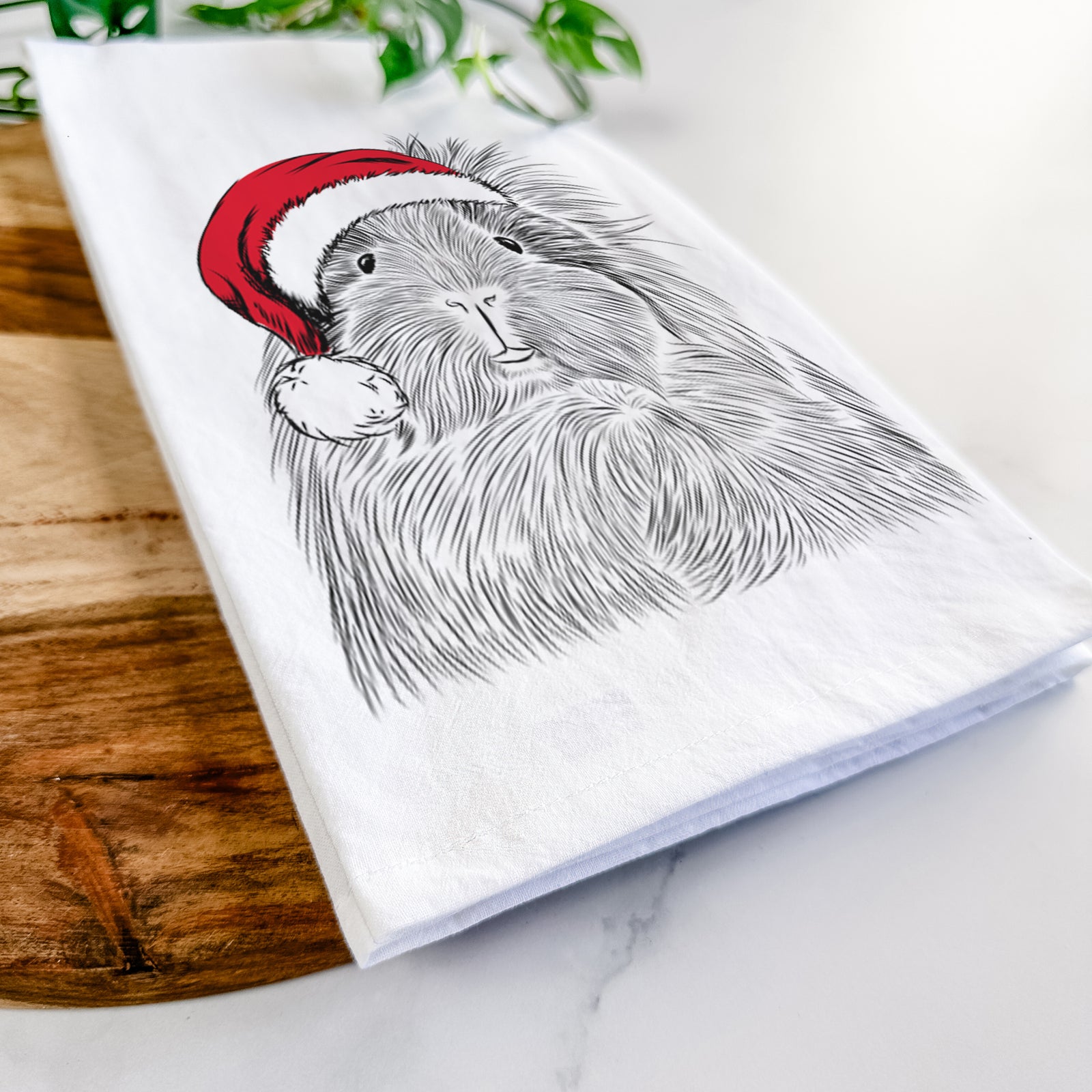 Hand-drawn sketch of Rhino the Guinea Pig wearing a Santa hat on a tea towel