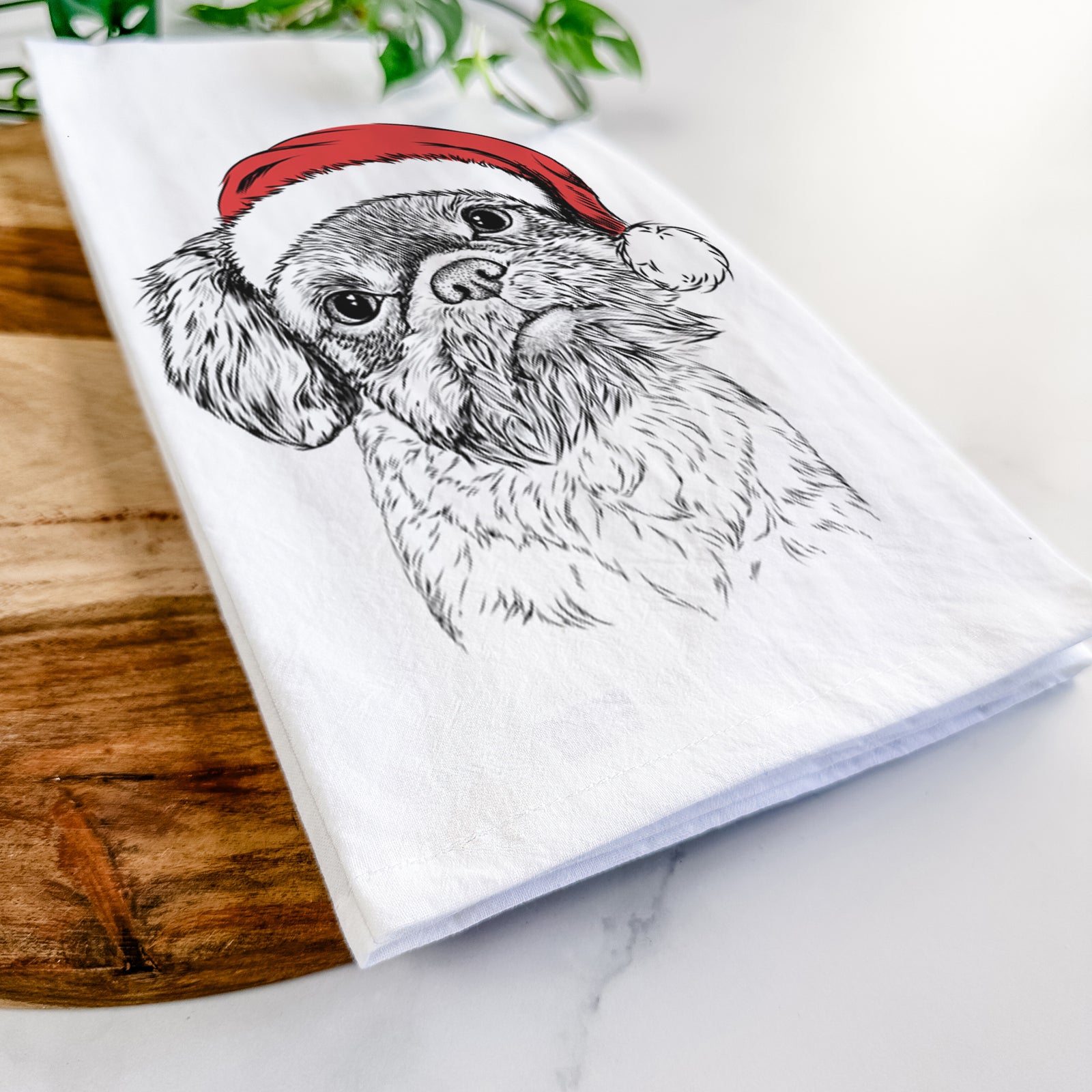 Hand-drawn sketch of Rufus the Shiffon wearing a Santa hat on a tea towel