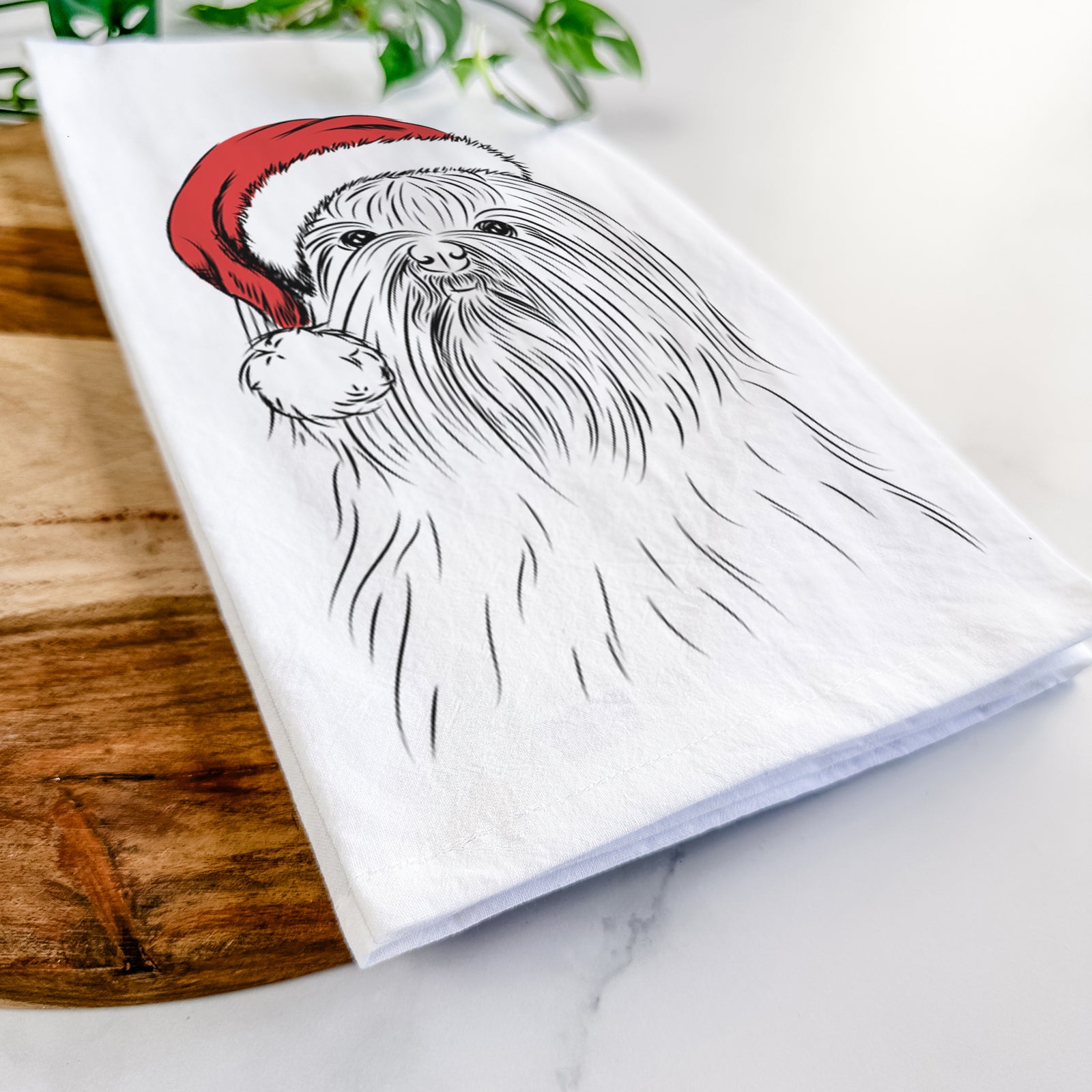 Hand-drawn sketch of Sabine the Shih Tzu wearing a Santa hat on a tea towel