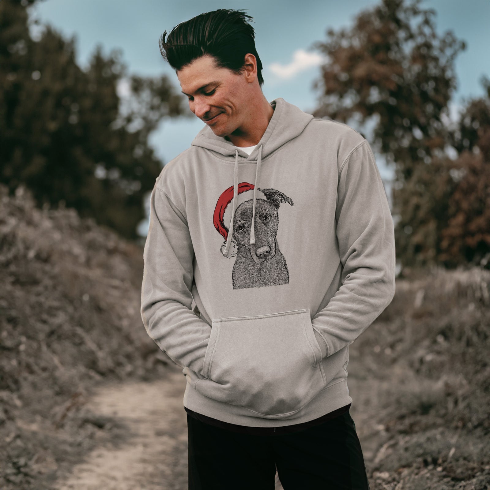 Hand-drawn sketch of Sadie the Whipador wearing a Santa hat on a Cement Unisex pigment dyed hoodie, worn by a man