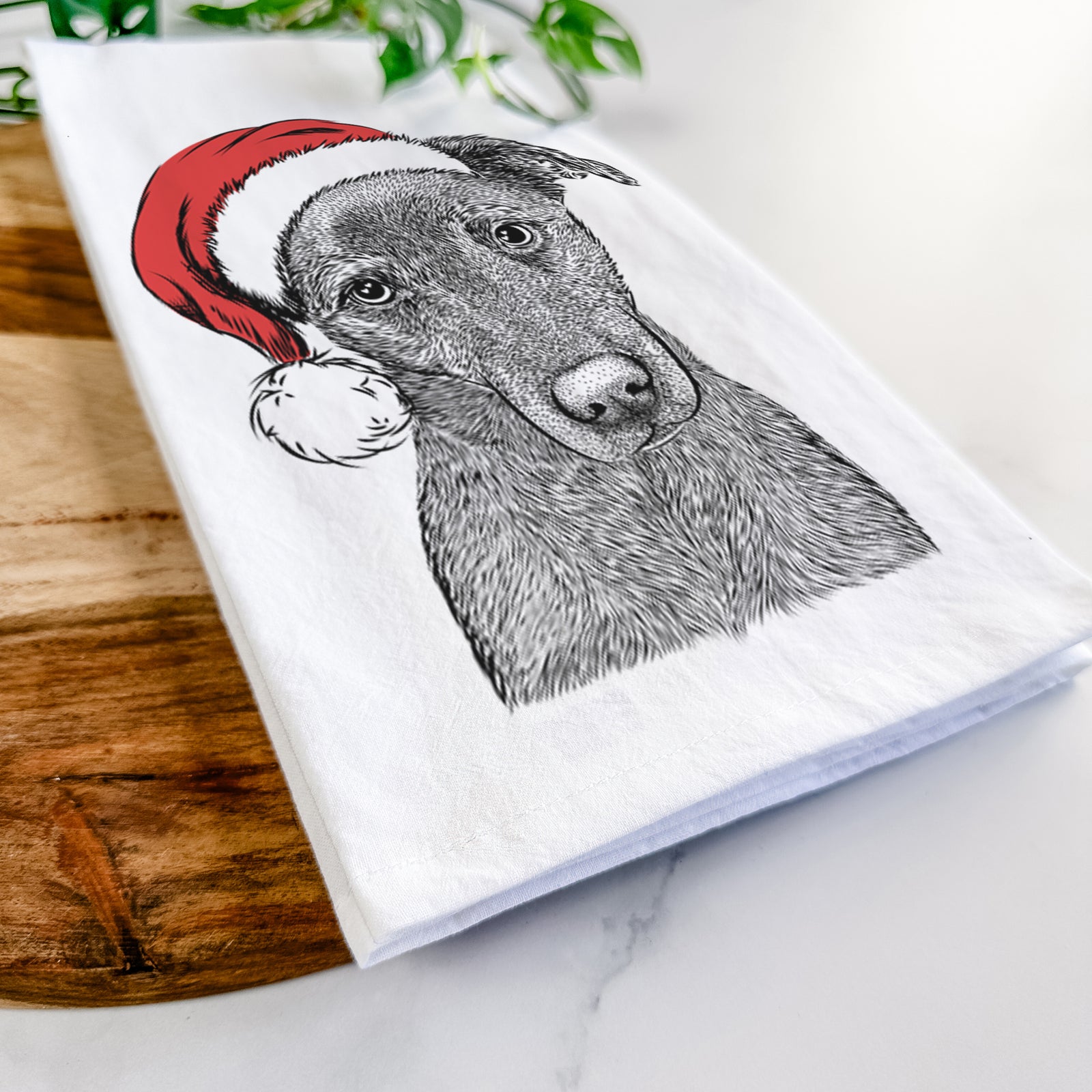 Hand-drawn sketch of Sadie the Whipador wearing a Santa hat on a tea towel