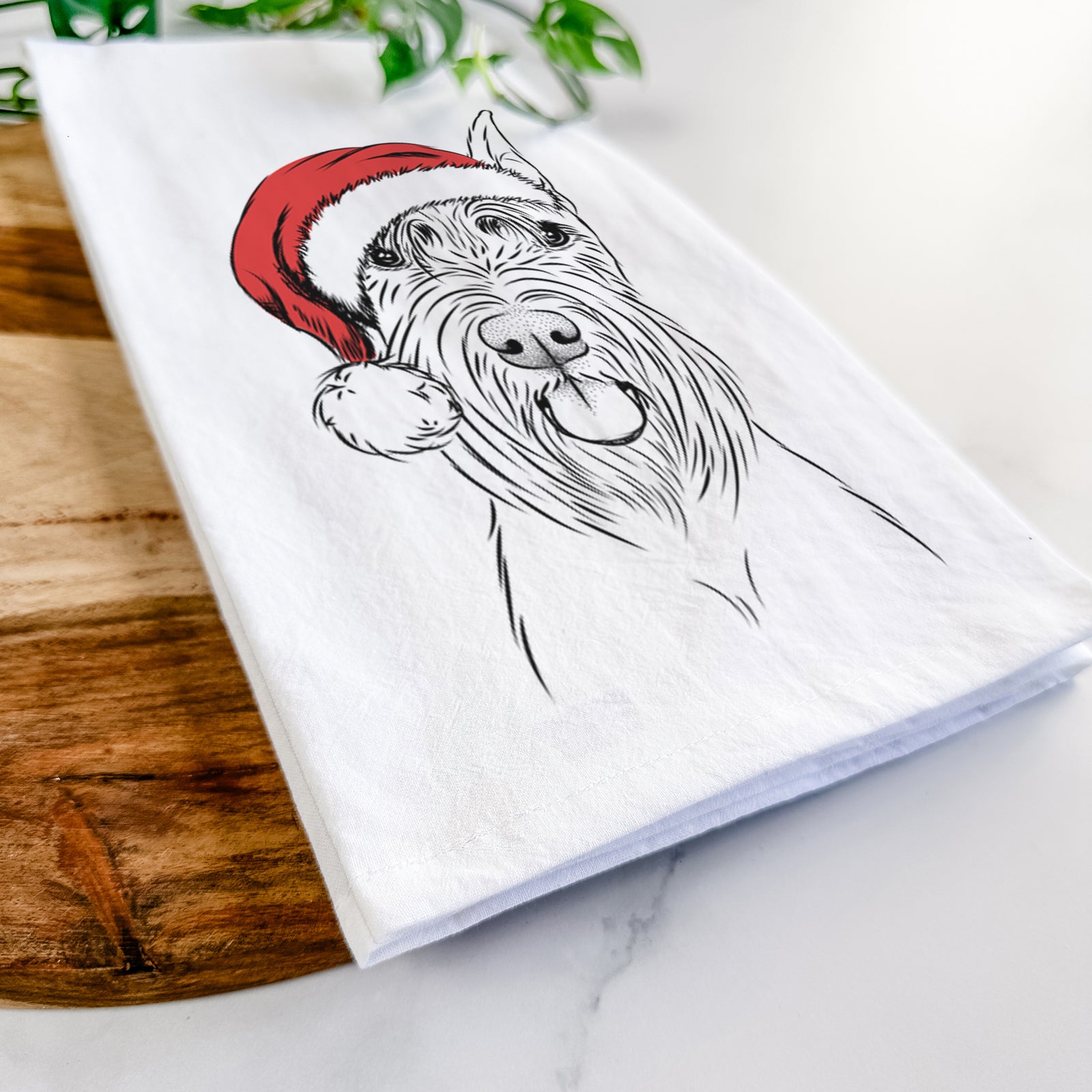 Hand-drawn sketch of Samuel the Standard Schnauzer wearing a Santa hat on a tea towel