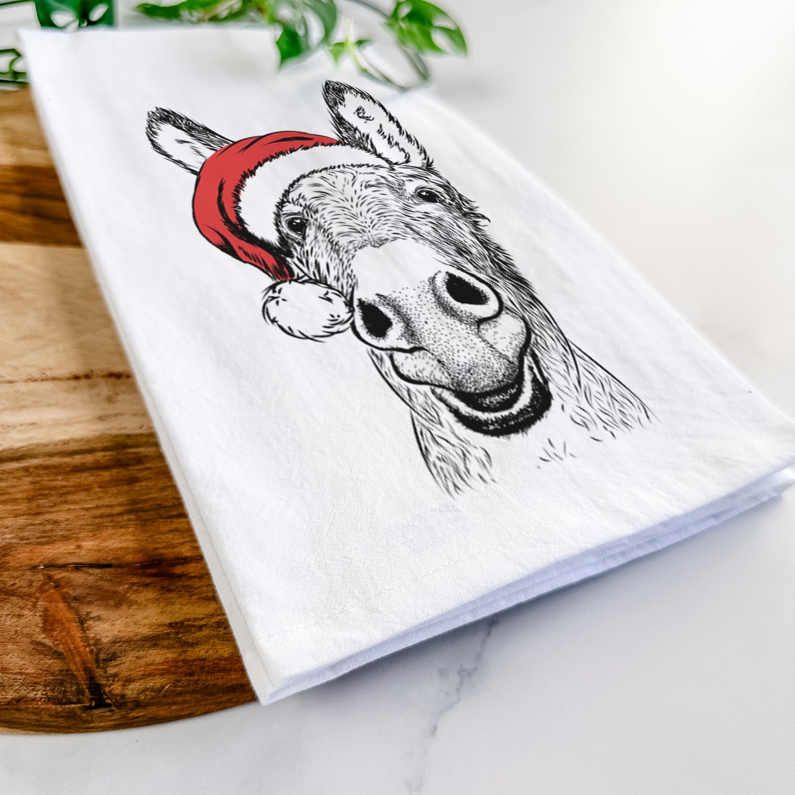 Hand-drawn sketch of Samule the Donkey wearing a Santa hat on a tea towel