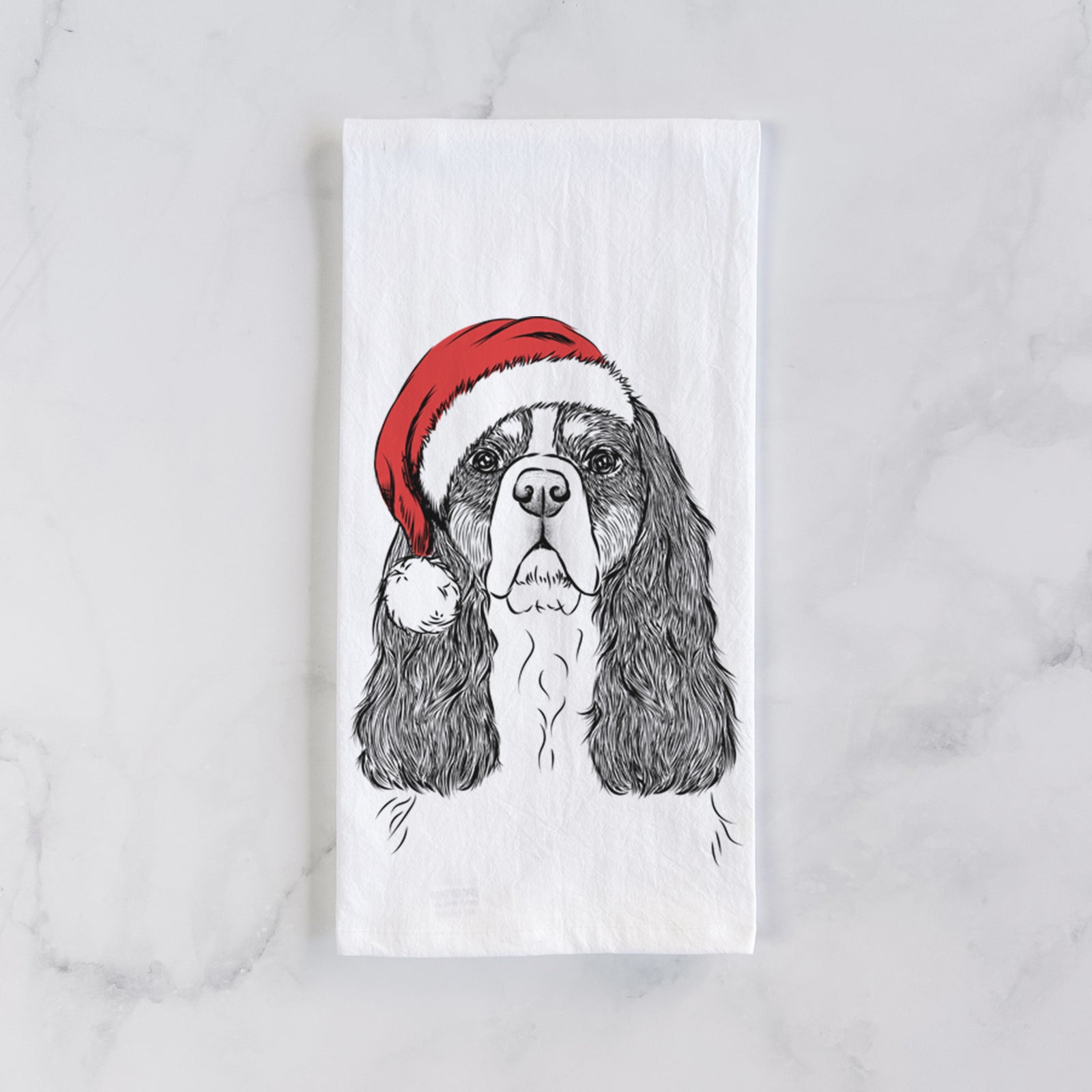 Hand-drawn sketch of Sebastian the Cavalier King Charles Spaniel wearing a Santa hat on a tea towel