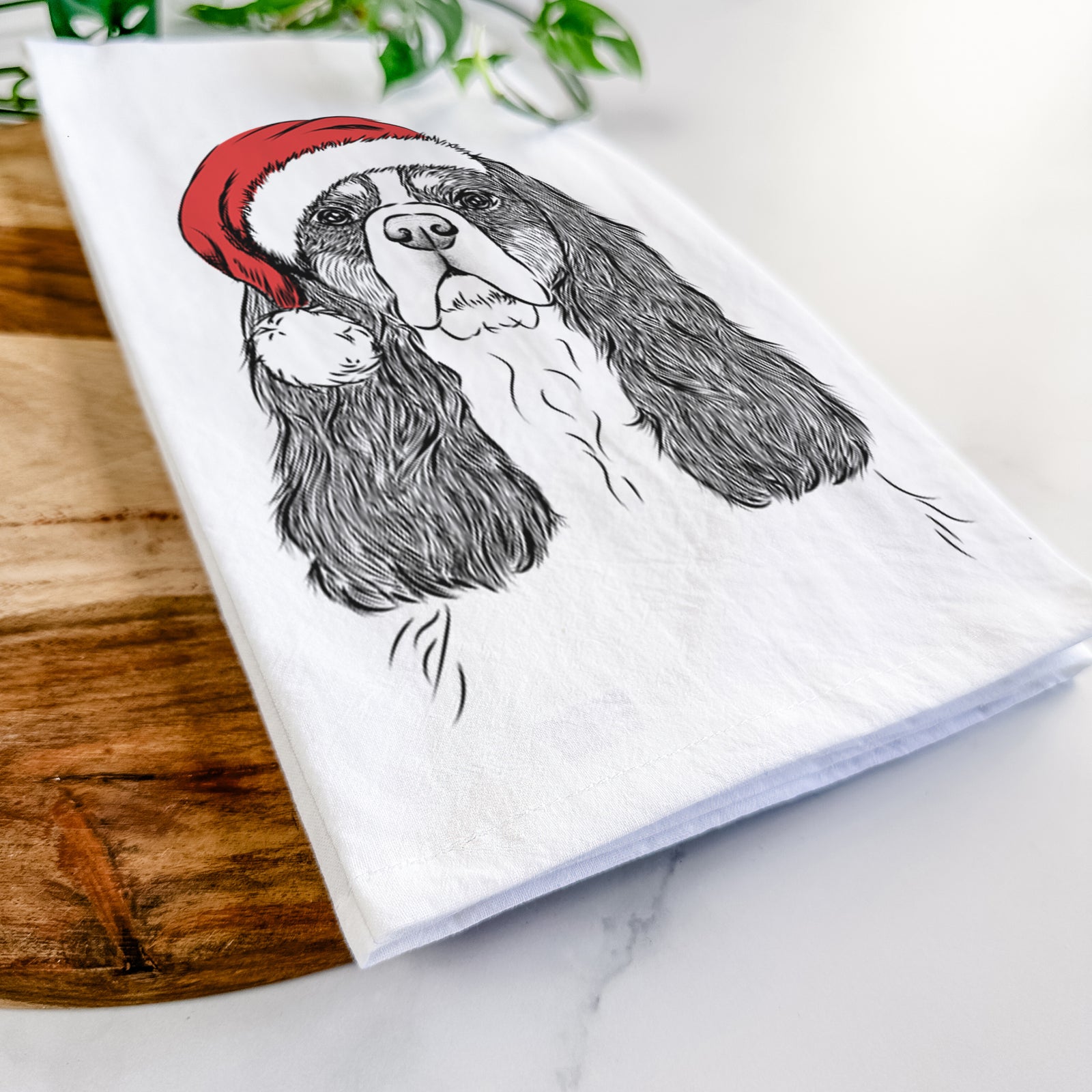 Hand-drawn sketch of Sebastian the Cavalier King Charles Spaniel wearing a Santa hat on a tea towel