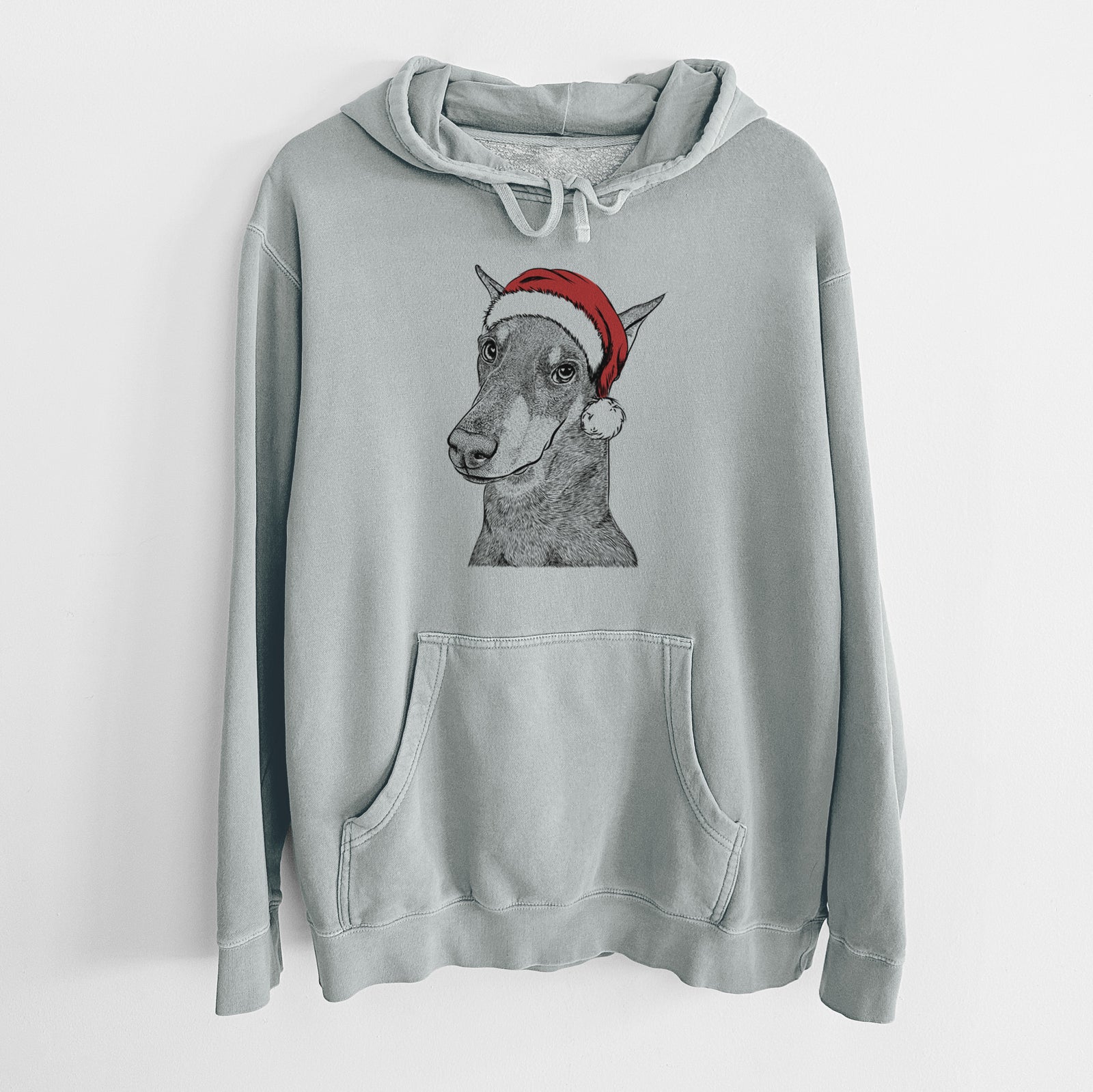 Hand-drawn sketch of Shelby the Doberman Pinscher wearing a Santa hat on a Sage Unisex pigment dyed hoodie