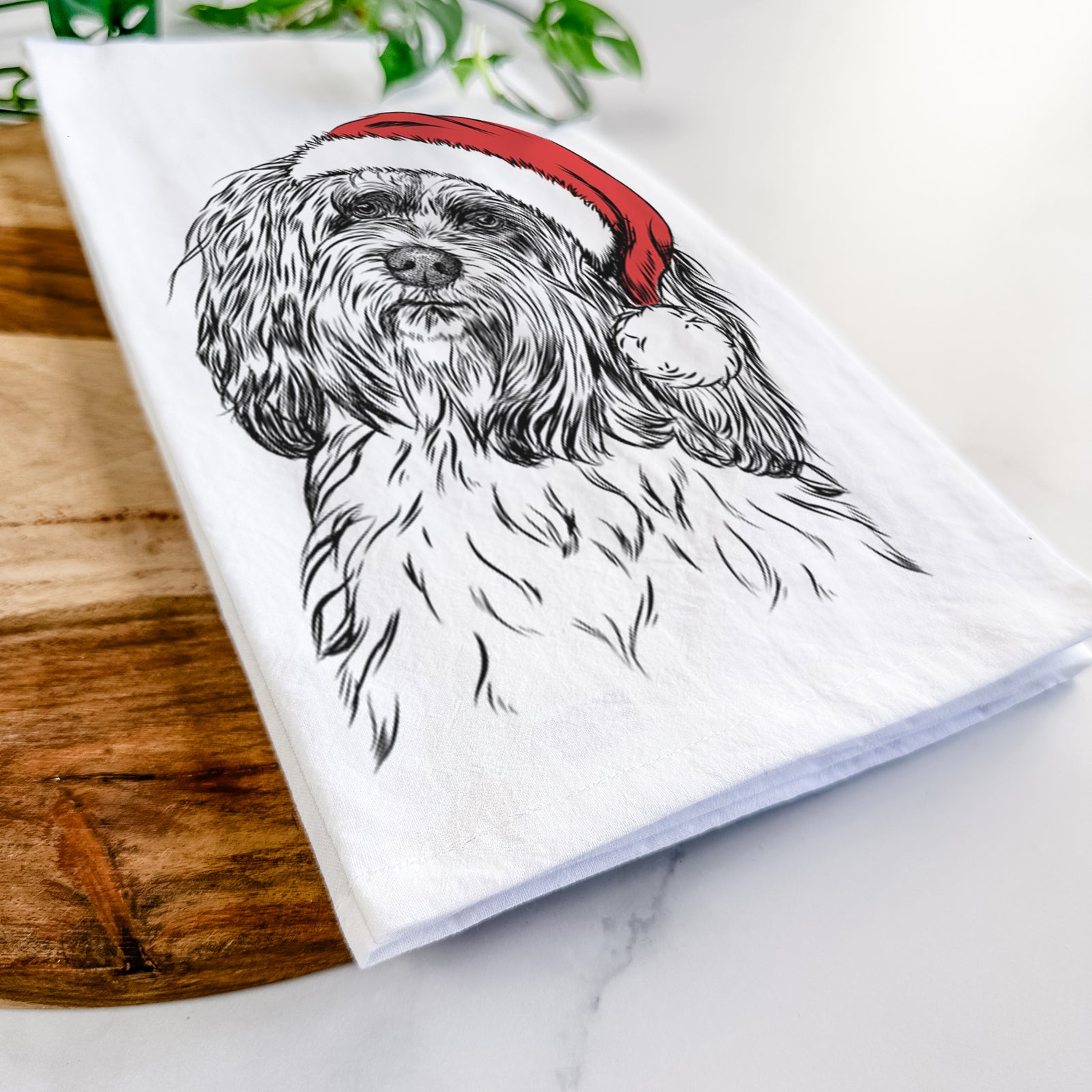 Hand-drawn sketch of Shenpa the Tibetan Terrier wearing a Santa hat on a tea towel