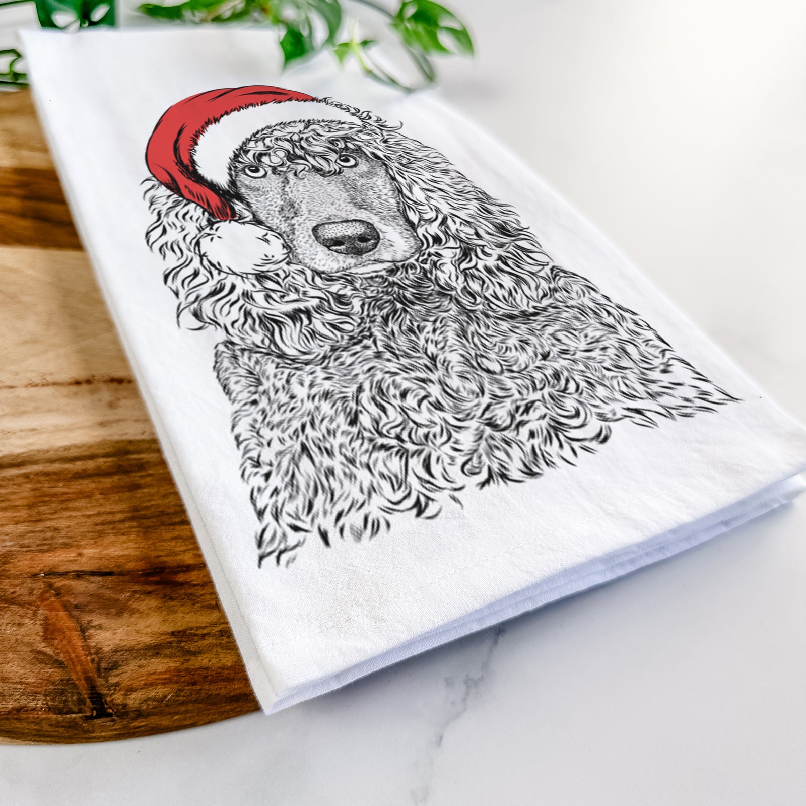 Hand-drawn sketch of Shilo the Irish Water Spaniel wearing a Santa hat on a tea towel