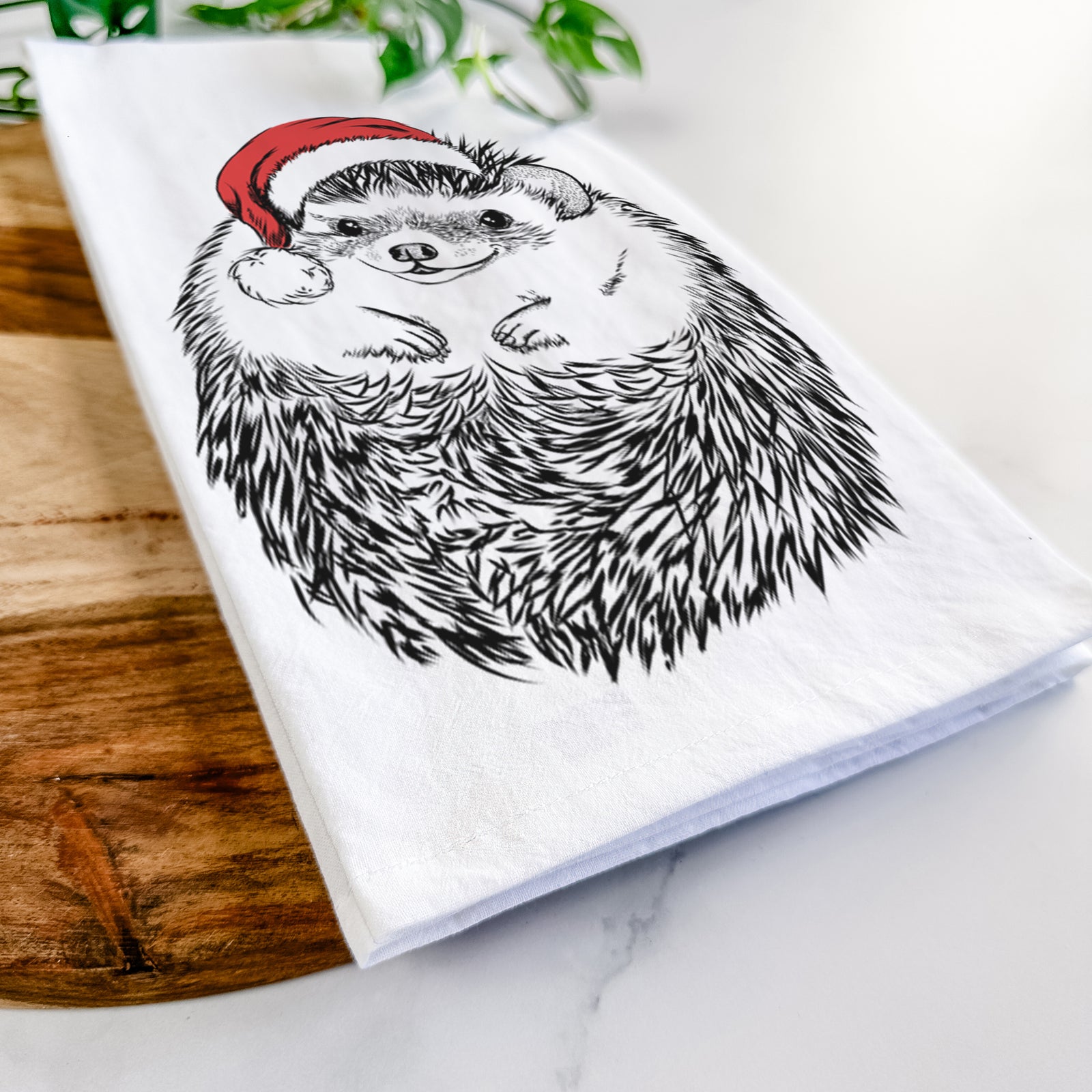 Hand-drawn sketch of Sid the Hedgehog wearing a Santa hat on a tea towel