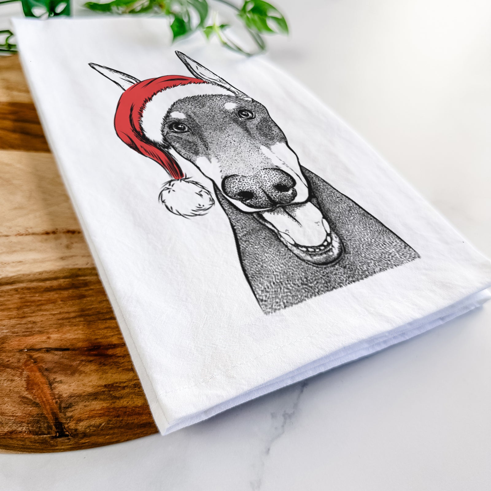 Hand-drawn sketch of Sir Duke the Doberman Pinscher wearing a Santa hat on a tea towel