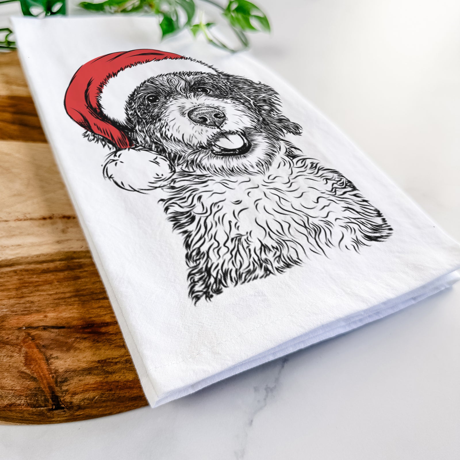 Hand-drawn sketch of Smoky the Bernedoodle Puppy wearing a Santa hat on a tea towel