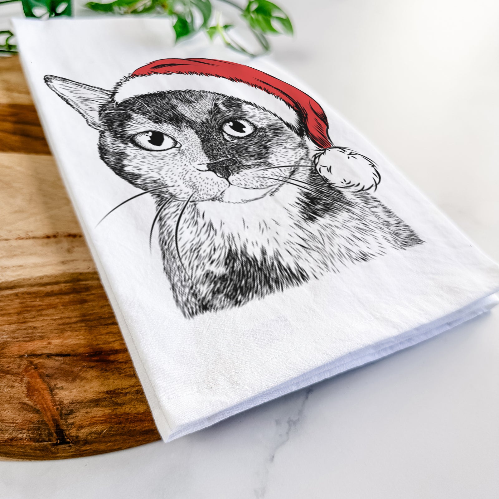 Hand-drawn sketch of Spooky Kitty the Tortoiseshell Cat wearing a Santa hat on a tea towel