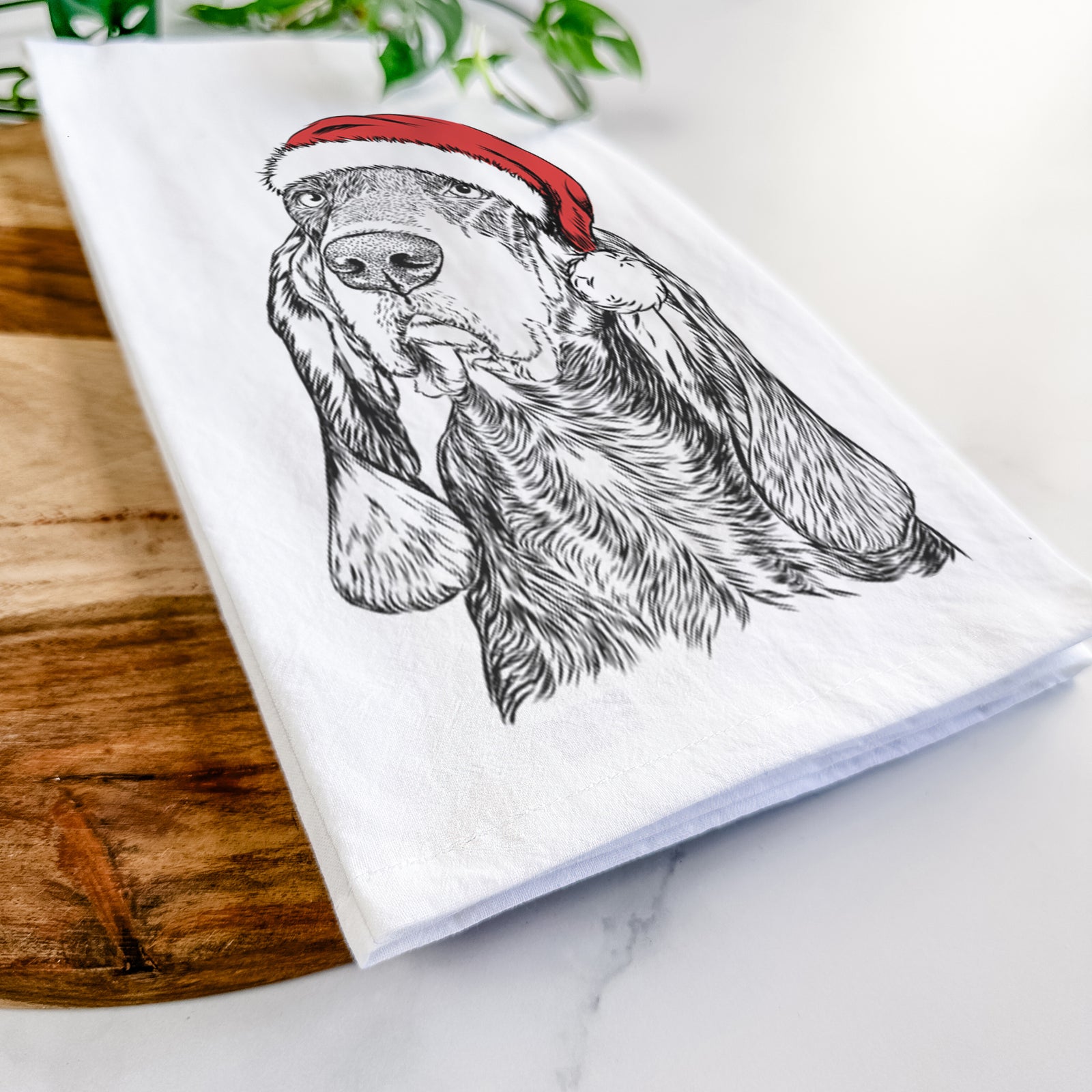 Hand-drawn sketch of Stu the Black and Tan Coonhound wearing a Santa hat on a tea towel