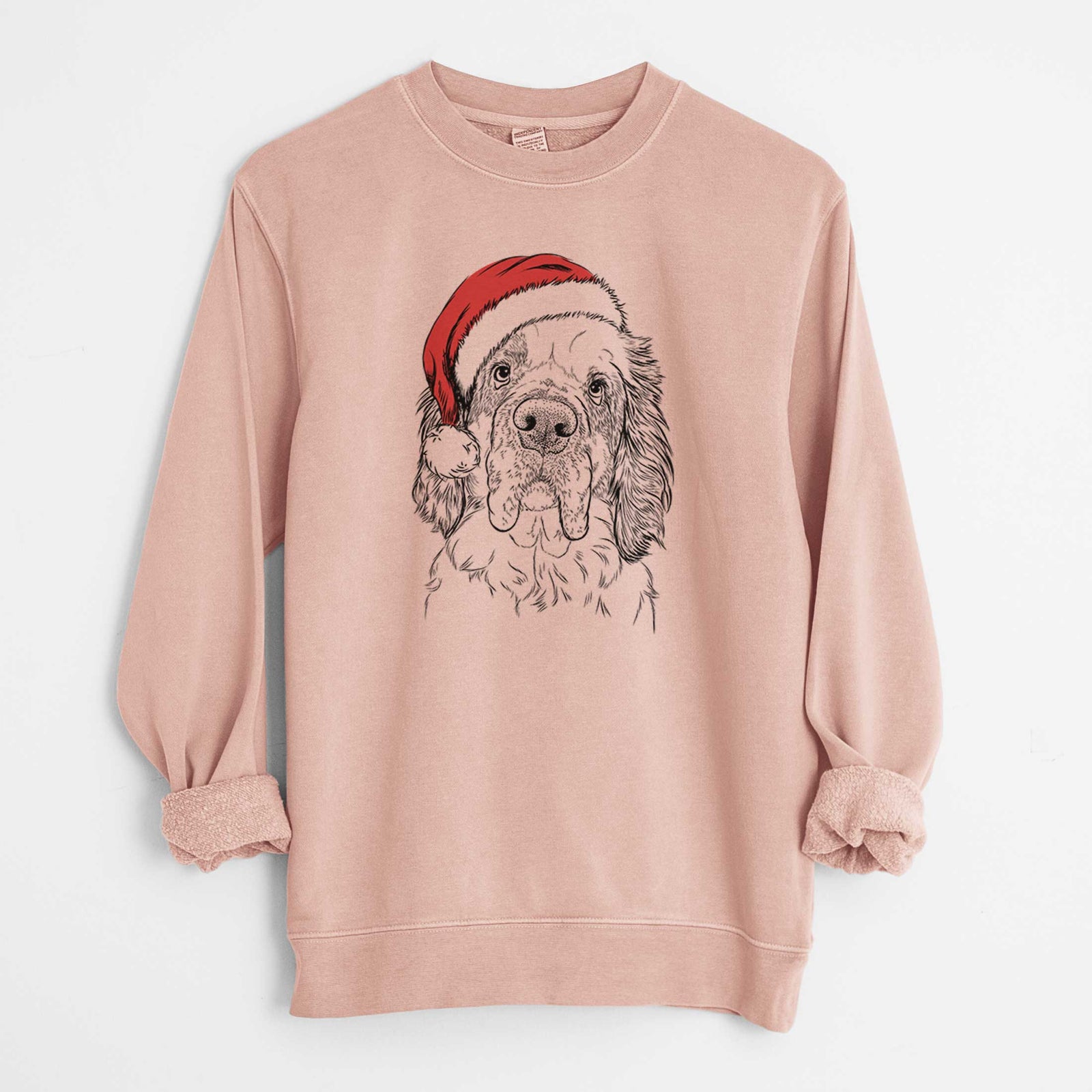 Hand-drawn sketch of Sully the Clumber Spaniel wearing a Santa hat on a Dusty Pink Unisex pigment dyed crew sweatshirt