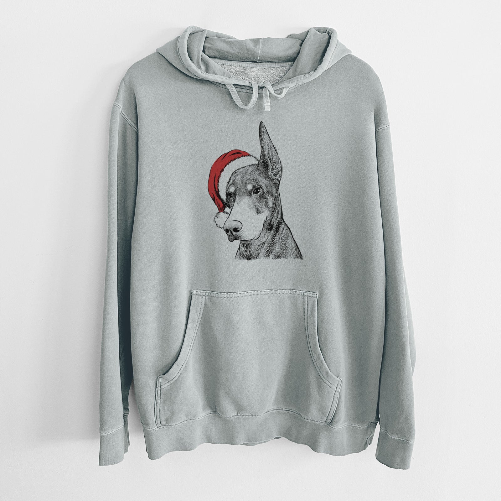 Hand-drawn sketch of Sunny the Doberman Pinscher wearing a Santa hat on a Sage Unisex pigment dyed hoodie