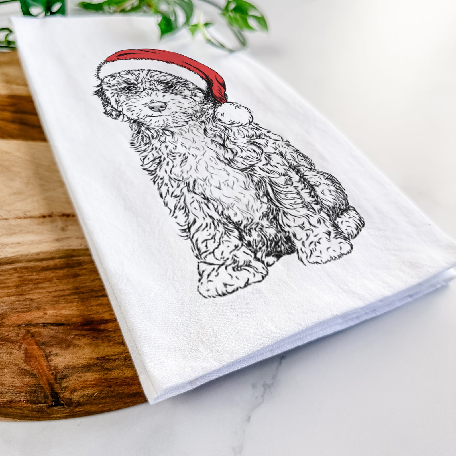 Hand-drawn sketch of Sweet Tea the Mini Doodle wearing a Santa hat on a tea towel