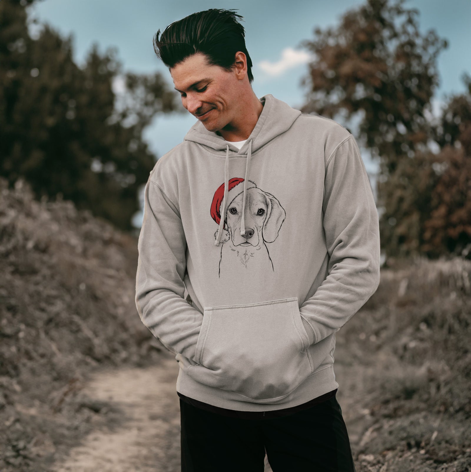 Hand-drawn sketch of Thea the Beagle wearing a Santa hat on a Cement Unisex pigment dyed hoodie, worn by a man