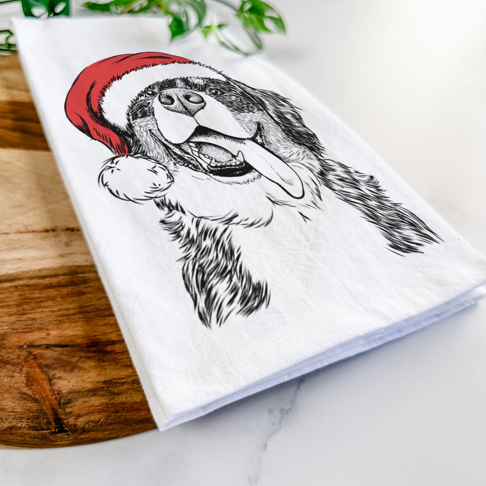 Hand-drawn sketch of Theo the Bernese Mountain Dog wearing a Santa hat on a tea towel