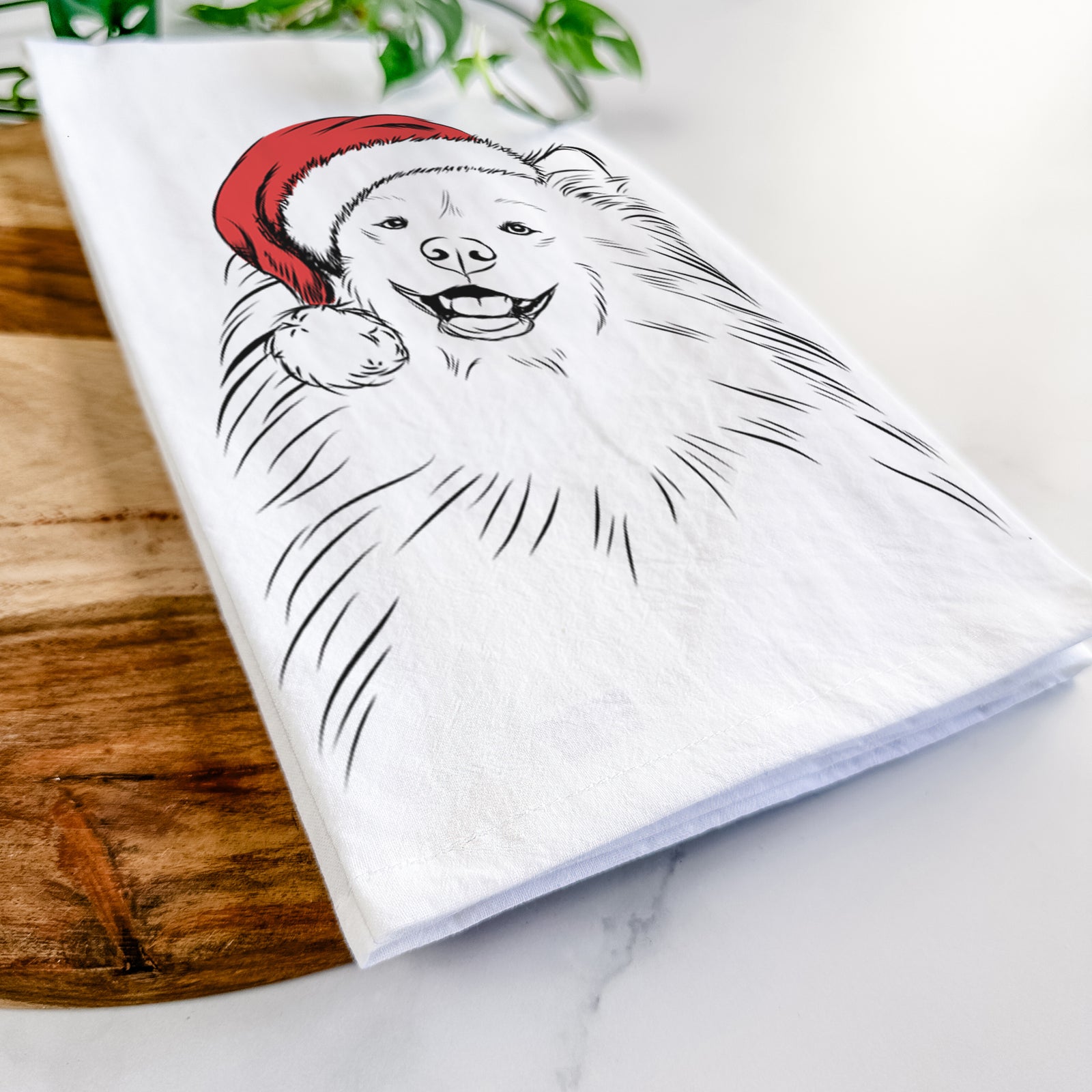 Hand-drawn sketch of Tillie the Samoyed wearing a Santa hat on a tea towel