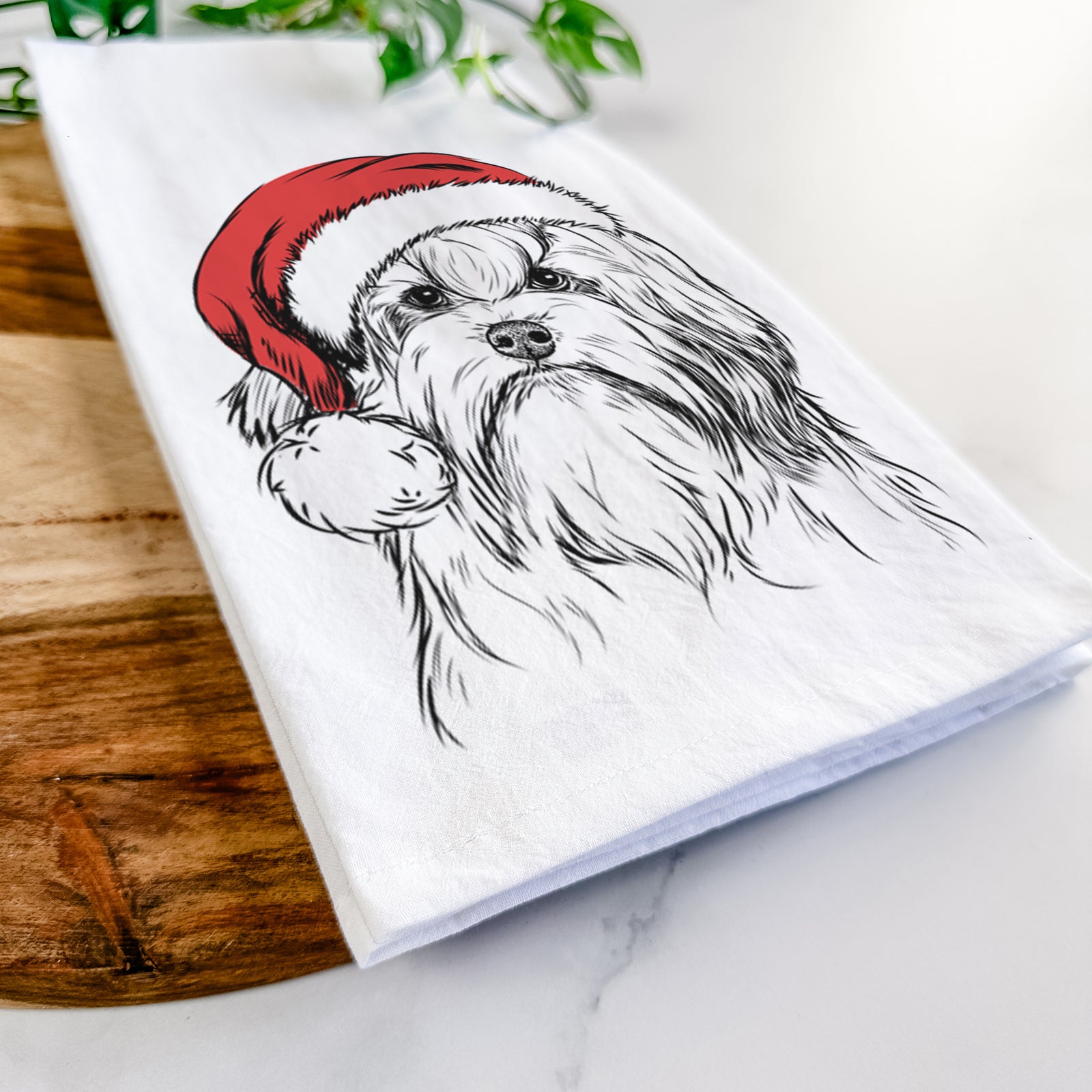 Hand-drawn sketch of Tootsie the Lowchen wearing a Santa hat on a tea towel
