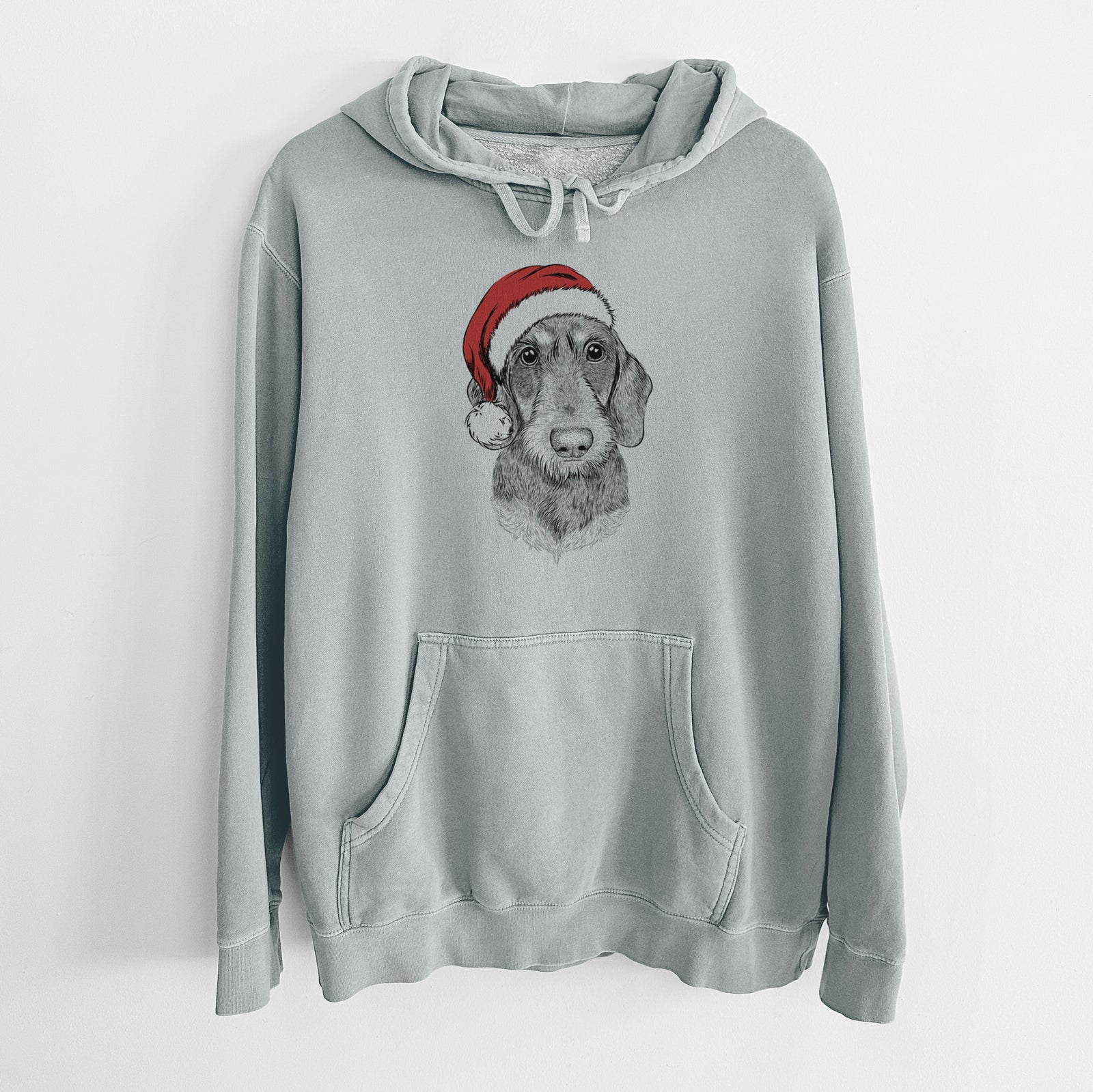 Hand-drawn sketch of Truman the Wirehaired Dachshund wearing a Santa hat on a Sage Unisex pigment dyed hoodie