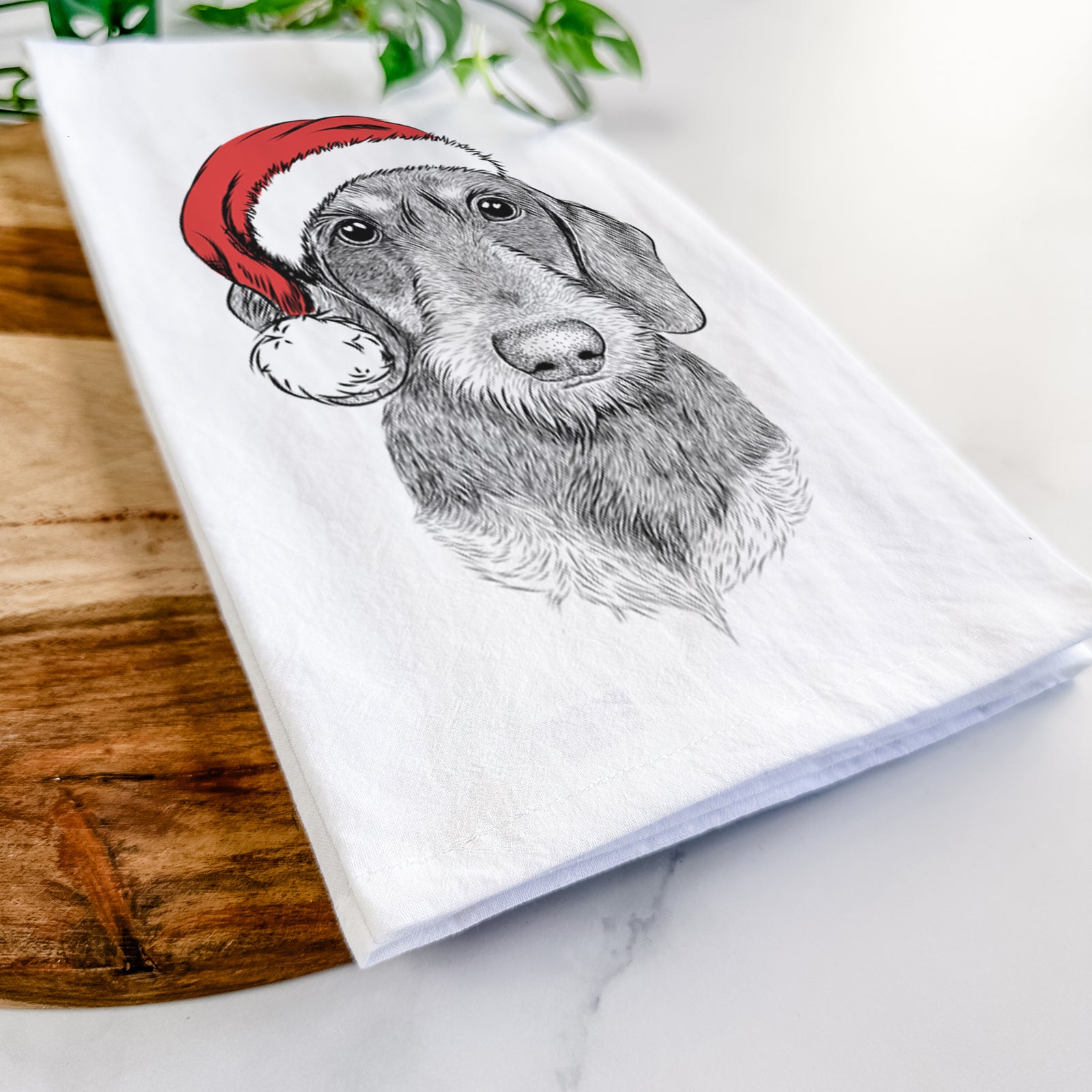 Hand-drawn sketch of Truman the Wirehaired Dachshund wearing a Santa hat on a tea towel