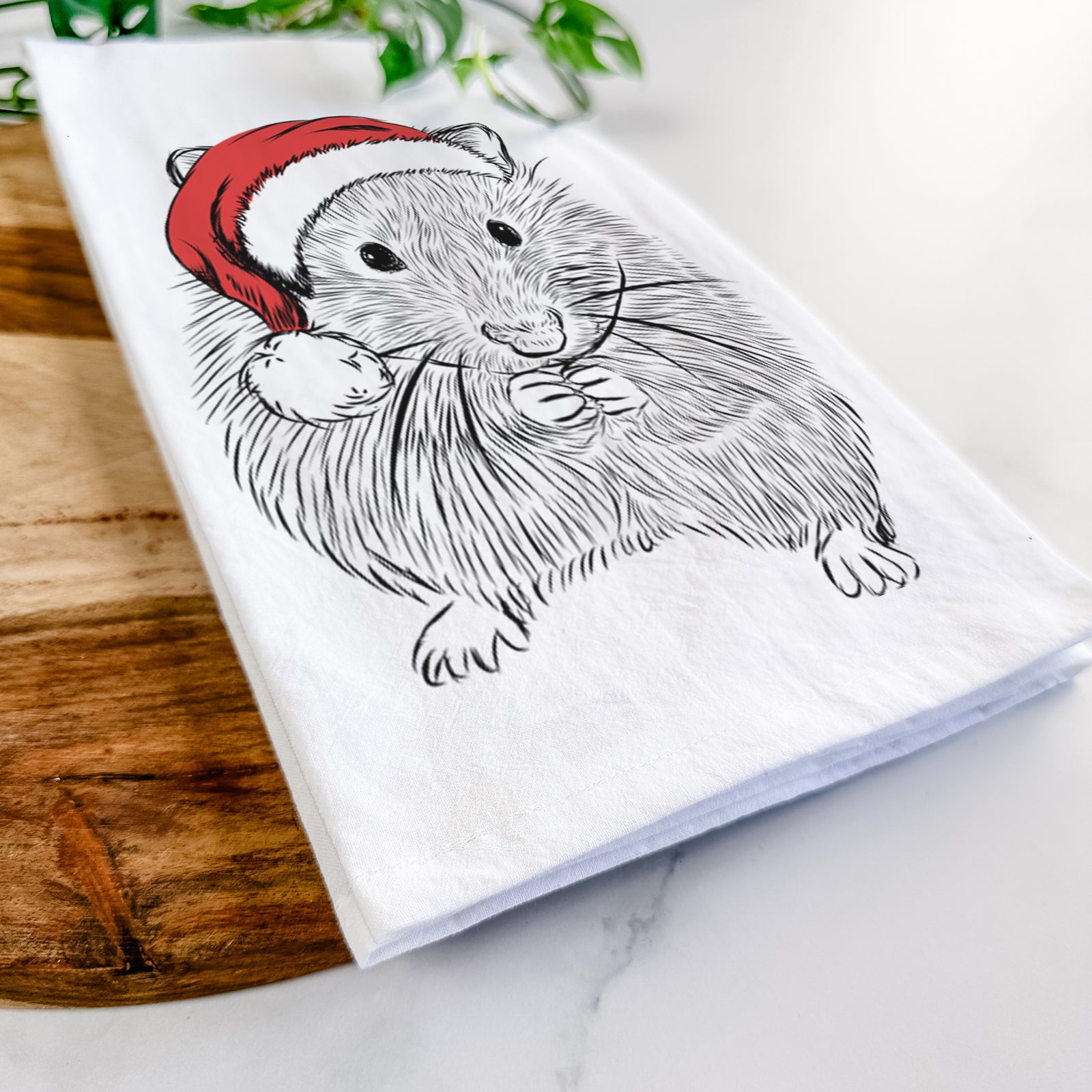 Hand-drawn sketch of Twitch the Hamster wearing a Santa hat on a tea towel