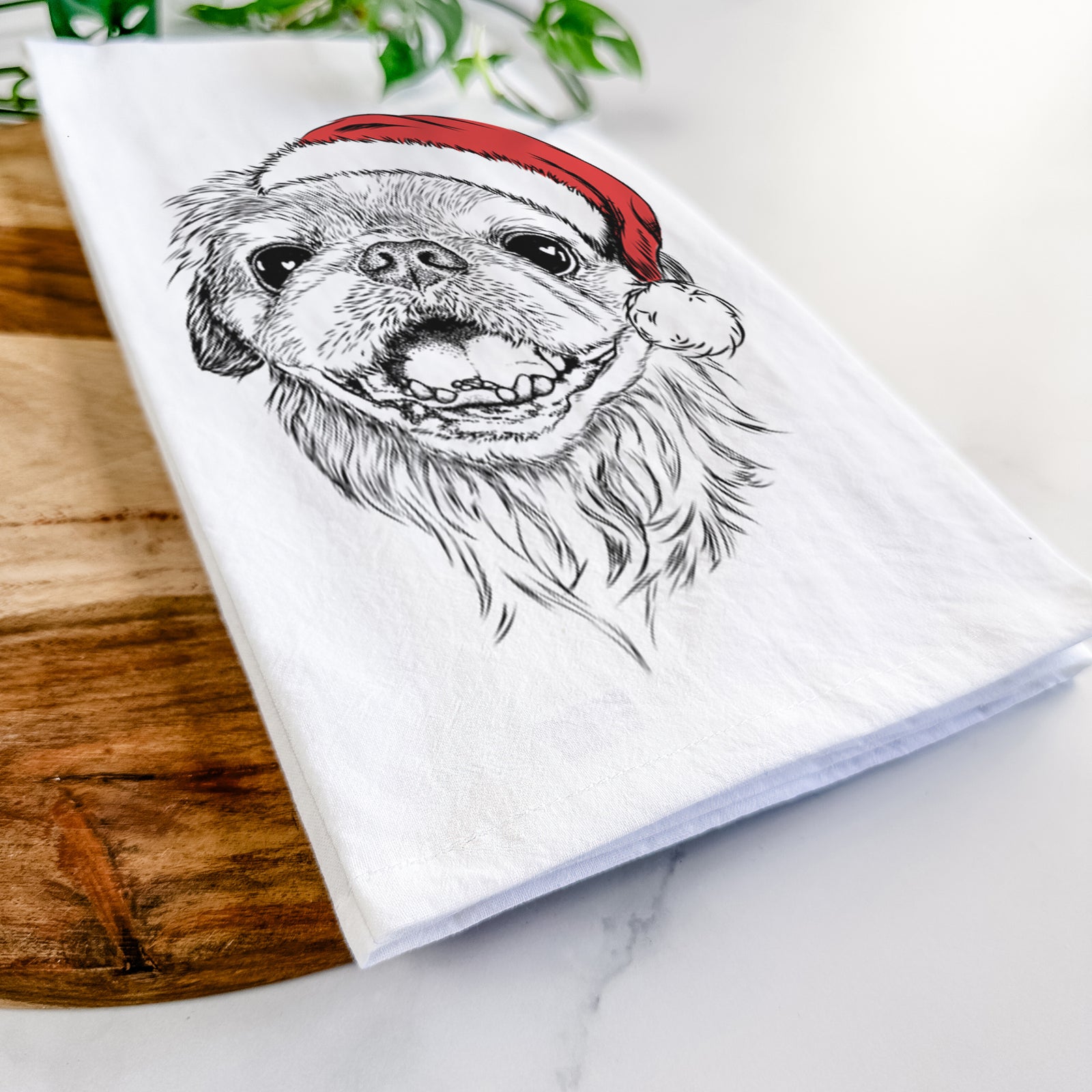 Hand-drawn sketch of Wally the Pekingese wearing a Santa hat on a tea towel