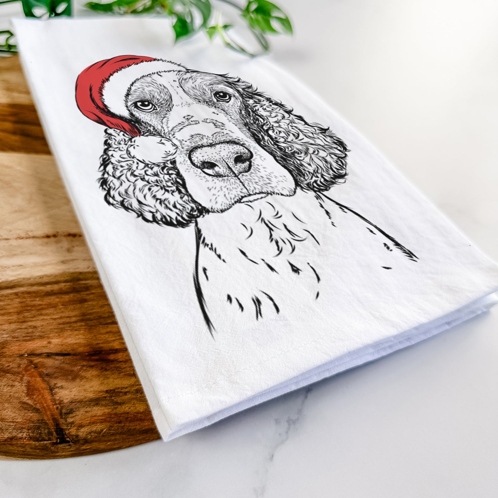 Hand-drawn sketch of Wilbur the English Springer Spaniel wearing a Santa hat on a tea towel