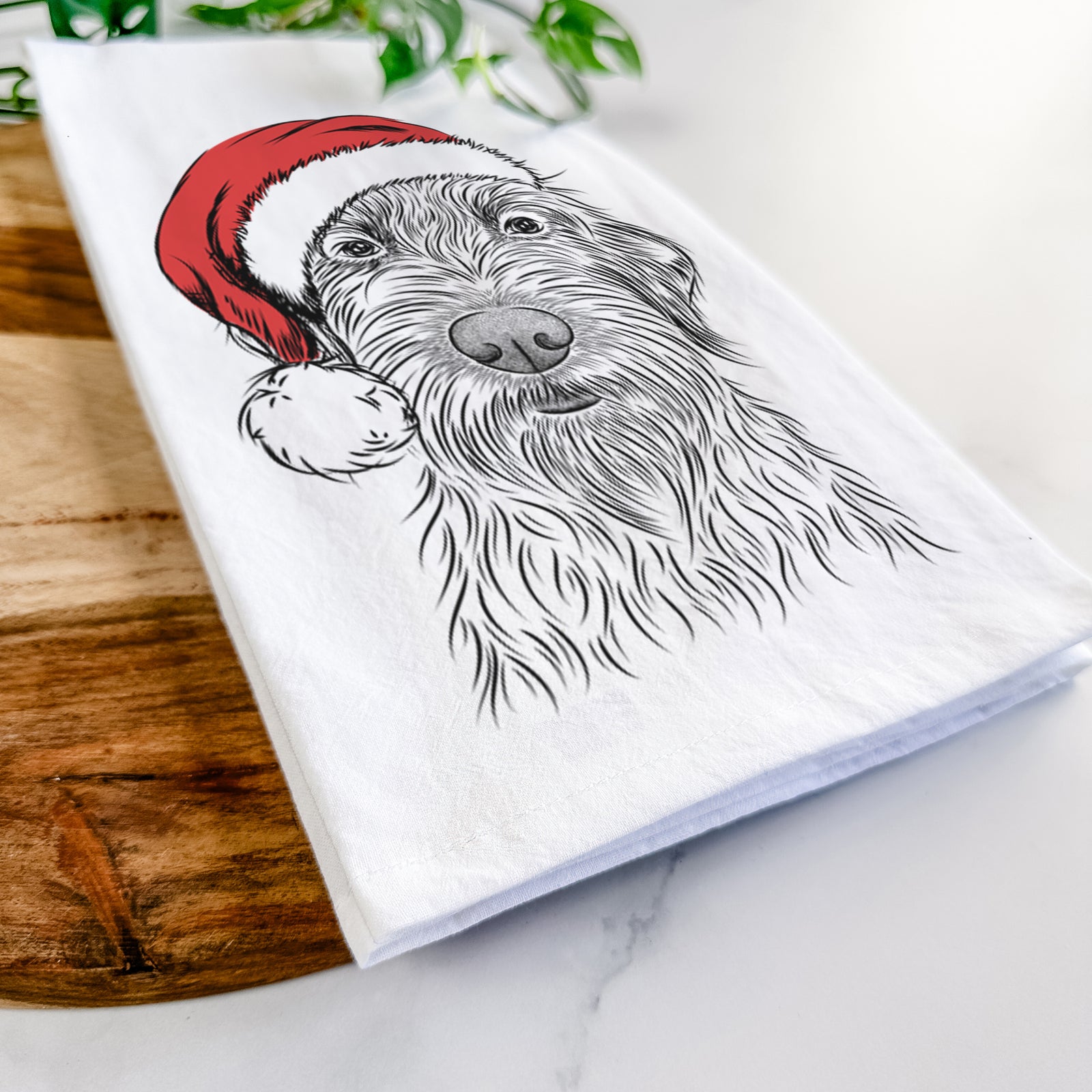 Hand-drawn sketch of Wilkins the Wirehaired Pointing Griffon wearing a Santa hat on a tea towel