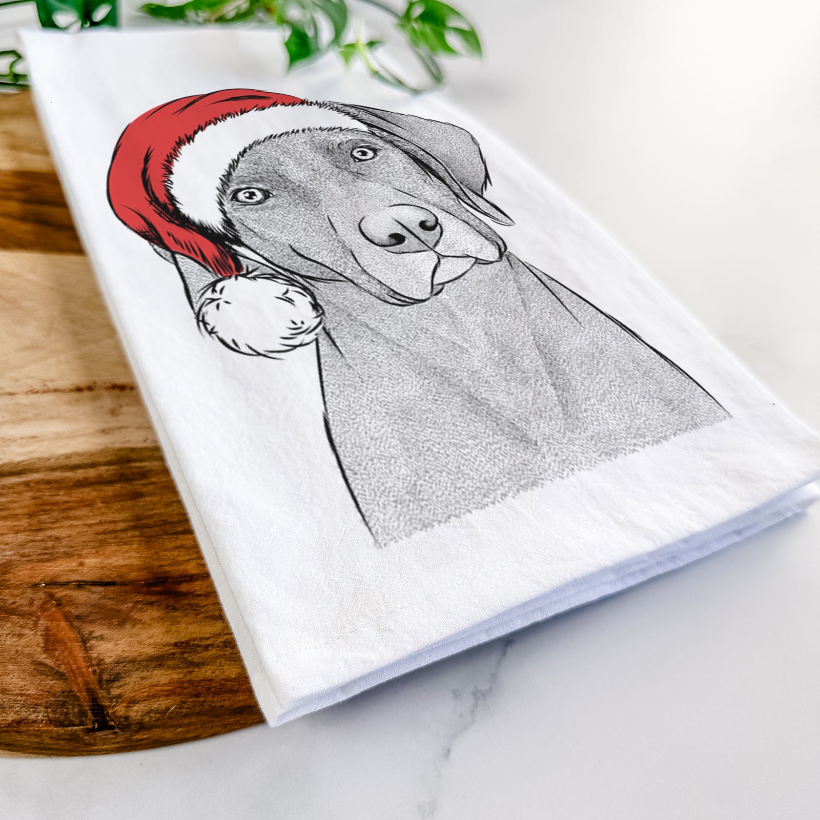 Hand-drawn sketch of Willow the Weizsla wearing a Santa hat on a tea towel