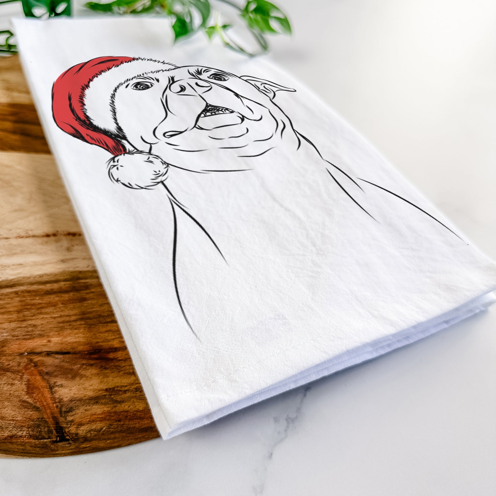 Hand-drawn sketch of Zada the Pitbull wearing a Santa hat on a tea towel