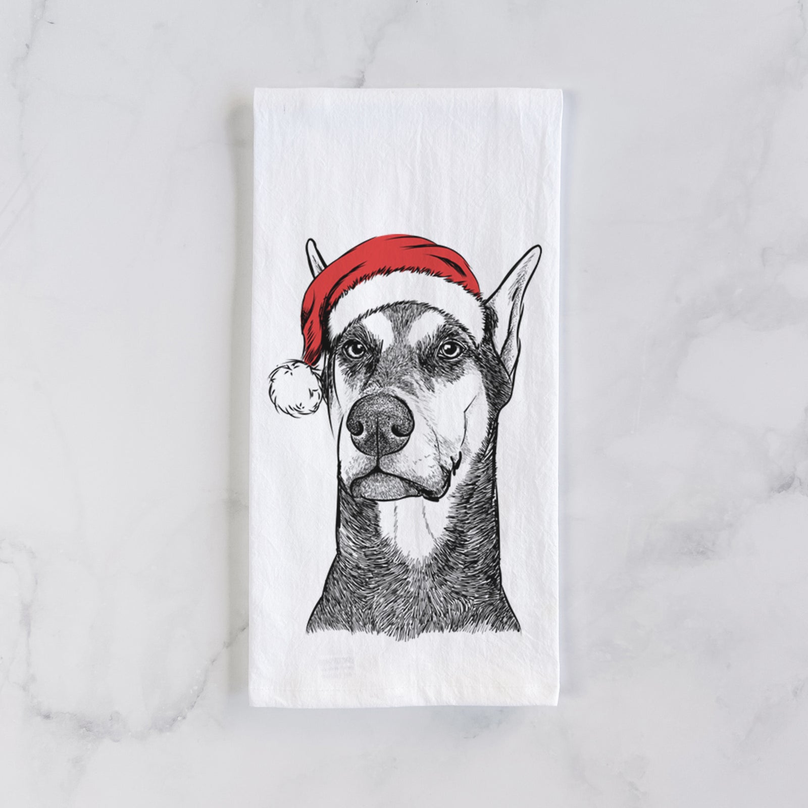 Hand-drawn sketch of Zeus the Doberman Pinscher wearing a Santa hat on a tea towel