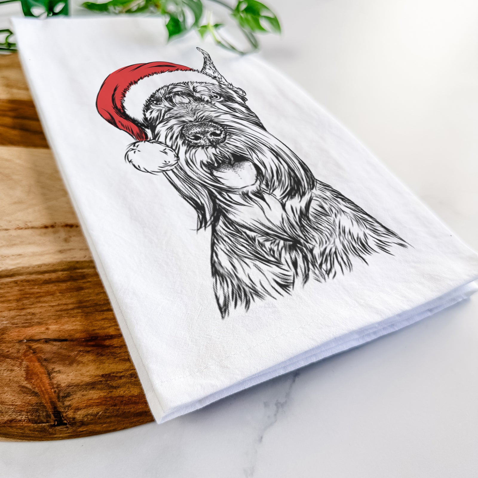 Hand-drawn sketch of Zuri the Giant Schnauzer wearing a Santa hat on a tea towel