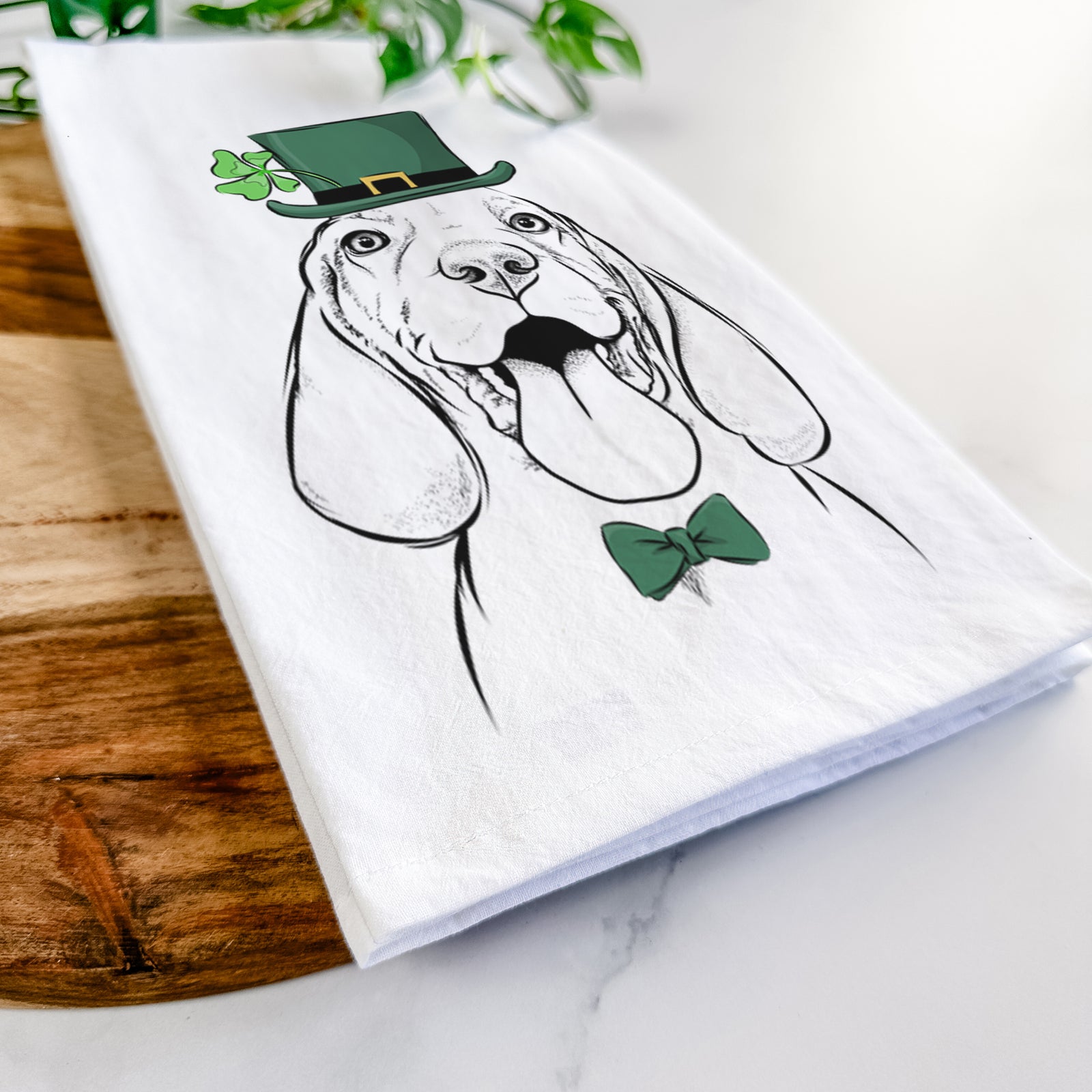 Hand-drawn sketch of Bodi the Vizsla wearing a St. Patrick's Day leprechaun hat and bow tie on a tea towel