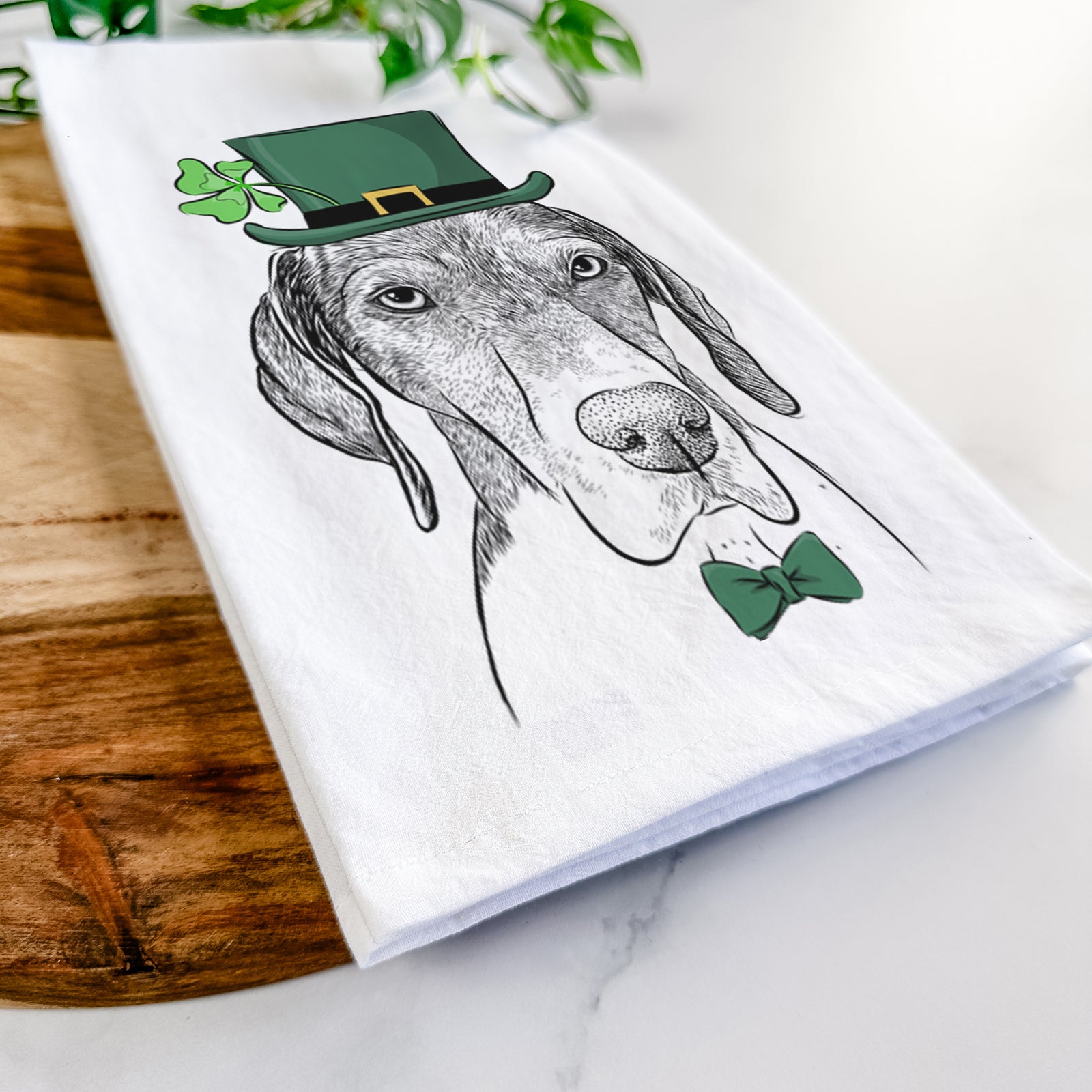 Hand-drawn sketch of Bohdi the German Shorthaired Pointer wearing a St. Patrick's Day leprechaun hat and bow tie on a tea towel