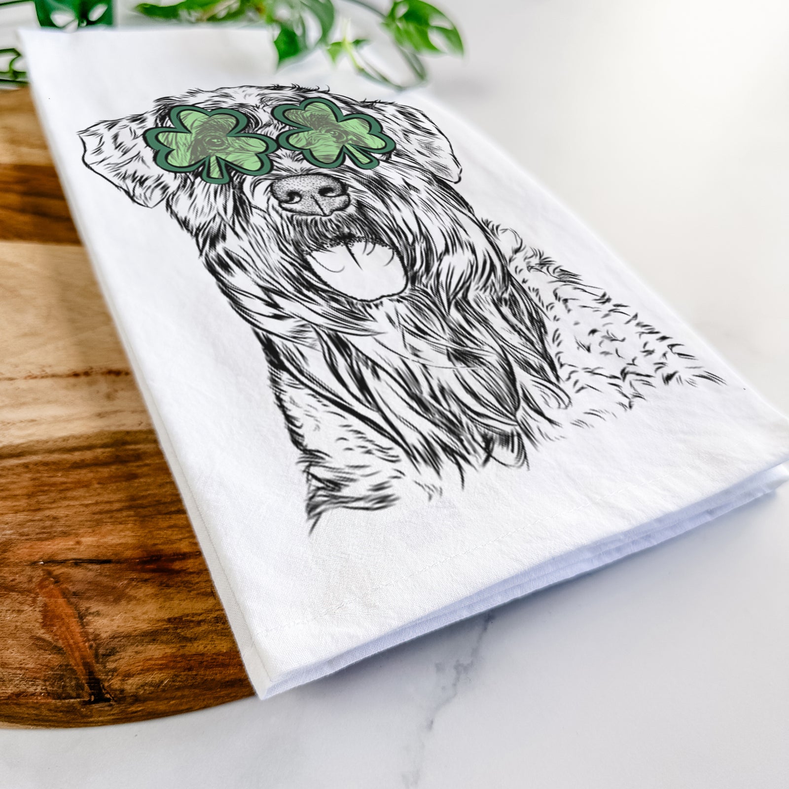 Hand-drawn sketch of Bonnie the Bouvier Des Flandres wearing a St. Patrick's Day leprechaun hat and bow tie on a tea towel