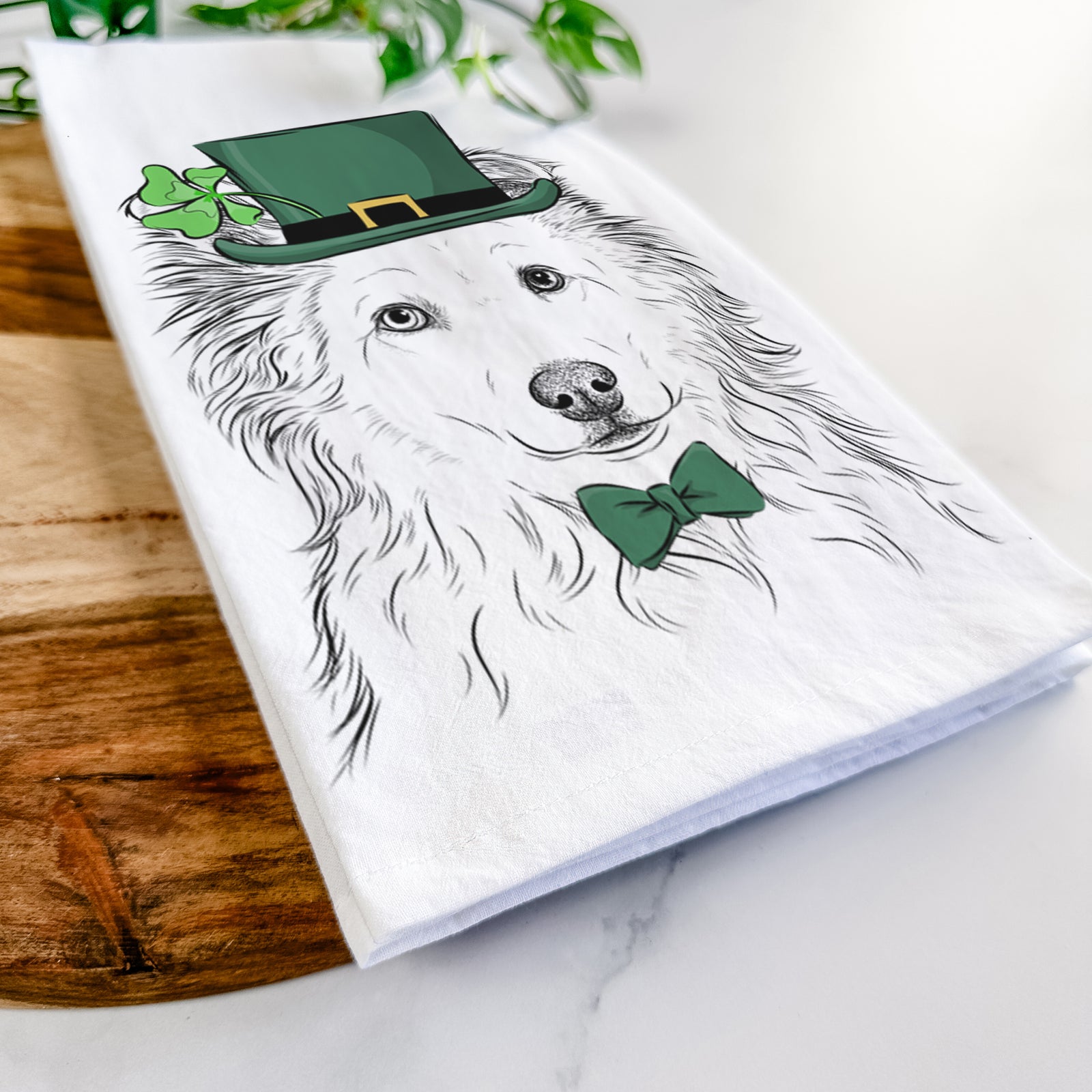 Hand-drawn sketch of Bonsai the Mixed Breed wearing a St. Patrick's Day leprechaun hat and bow tie on a tea towel