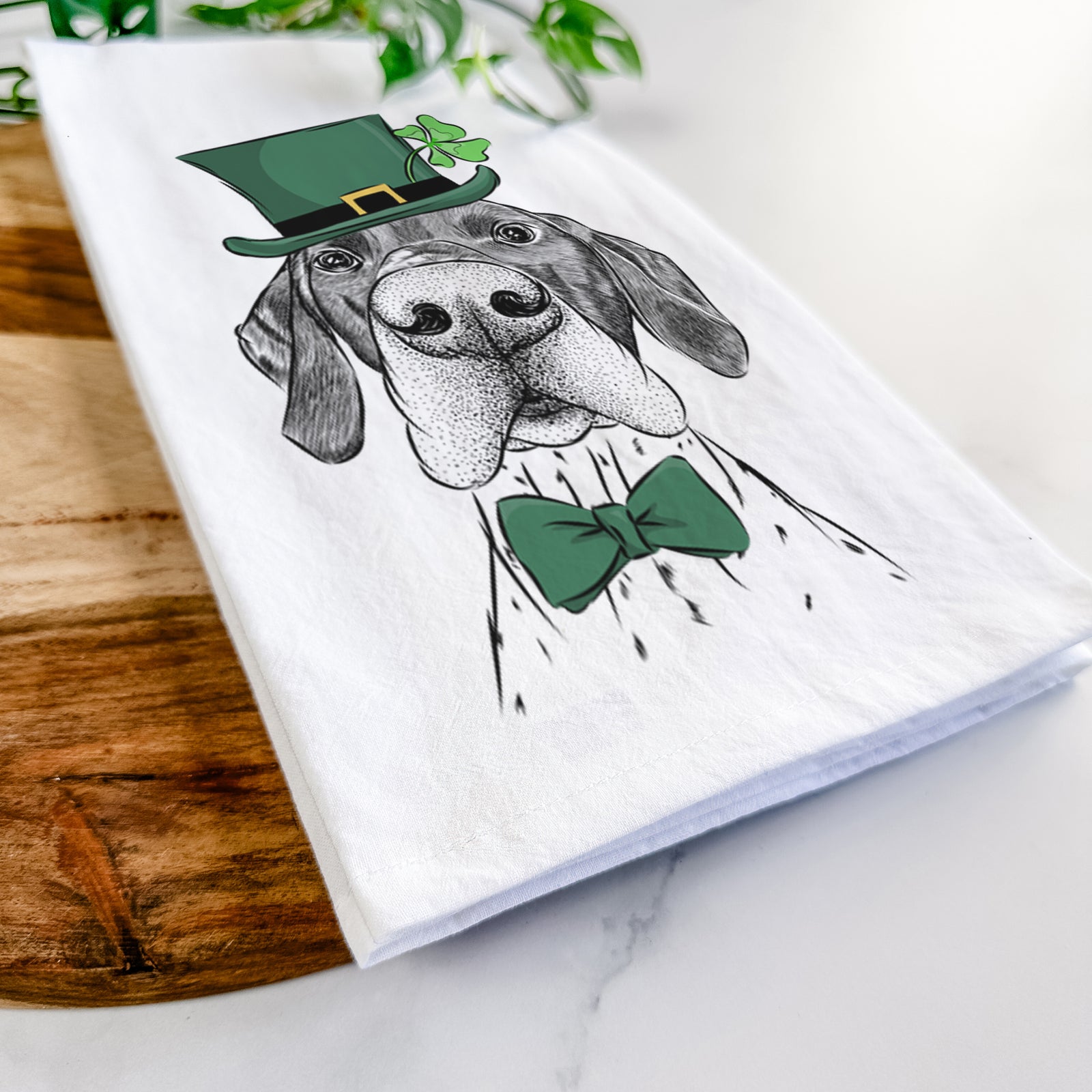Hand-drawn sketch of Booze the German Shorthaired Pointer wearing a St. Patrick's Day leprechaun hat and bow tie on a tea towel