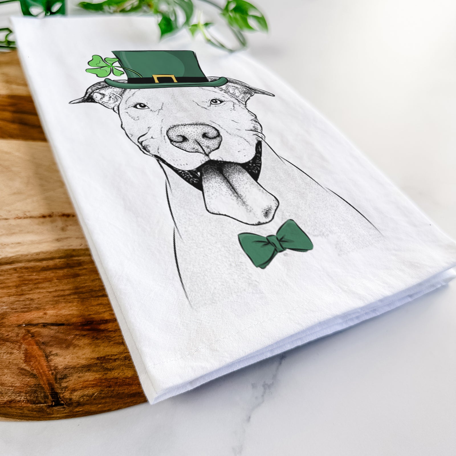 Hand-drawn sketch of Bruce the American Staffordshire Terrier wearing a St. Patrick's Day leprechaun hat and bow tie on a tea towel