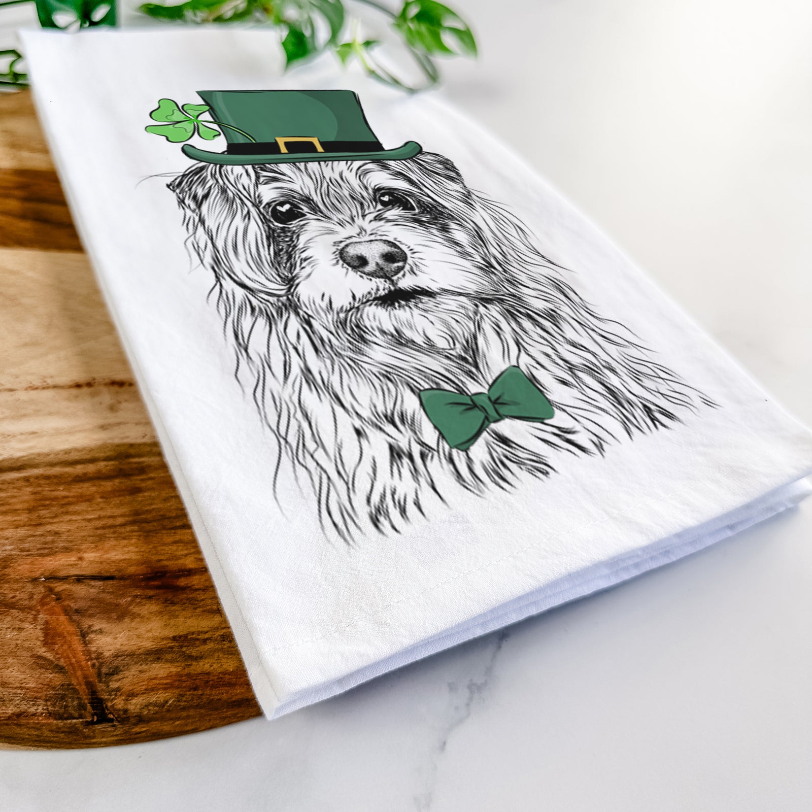 Hand-drawn sketch of Chester the Terrier Mix wearing a St. Patrick's Day leprechaun hat and bow tie on a tea towel