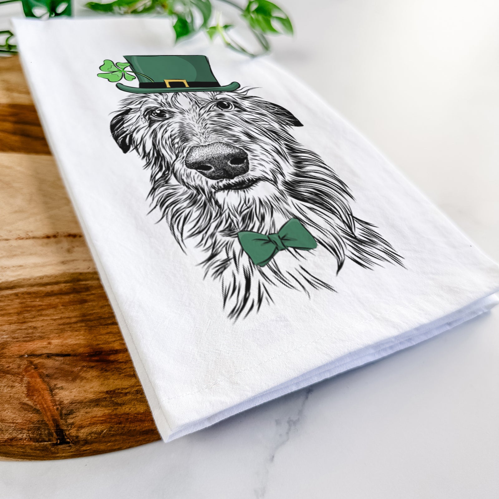 Hand-drawn sketch of Cleod the Scottish Deerhound wearing a St. Patrick's Day leprechaun hat and bow tie on a tea towel
