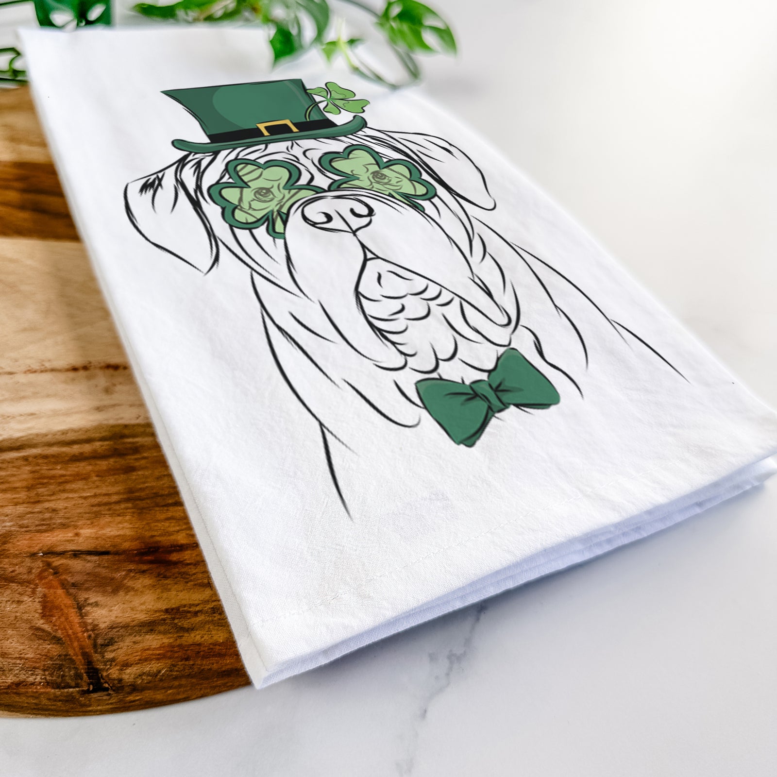 Hand-drawn sketch of Felix the Dogue de Bordeaux wearing a St. Patrick's Day leprechaun hat and bow tie on a tea towel