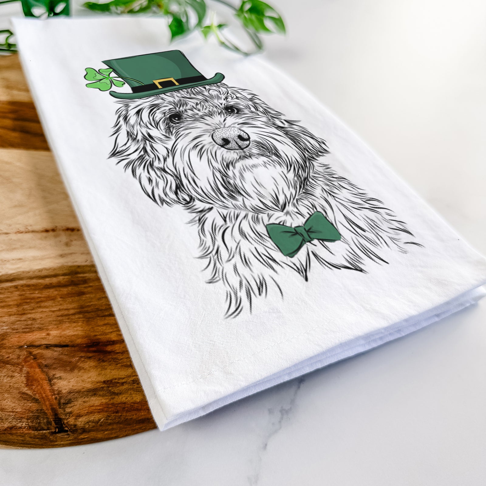 Hand-drawn sketch of Huckleberry the Australian Labradoodle wearing a St. Patrick's Day leprechaun hat and bow tie on a tea towel